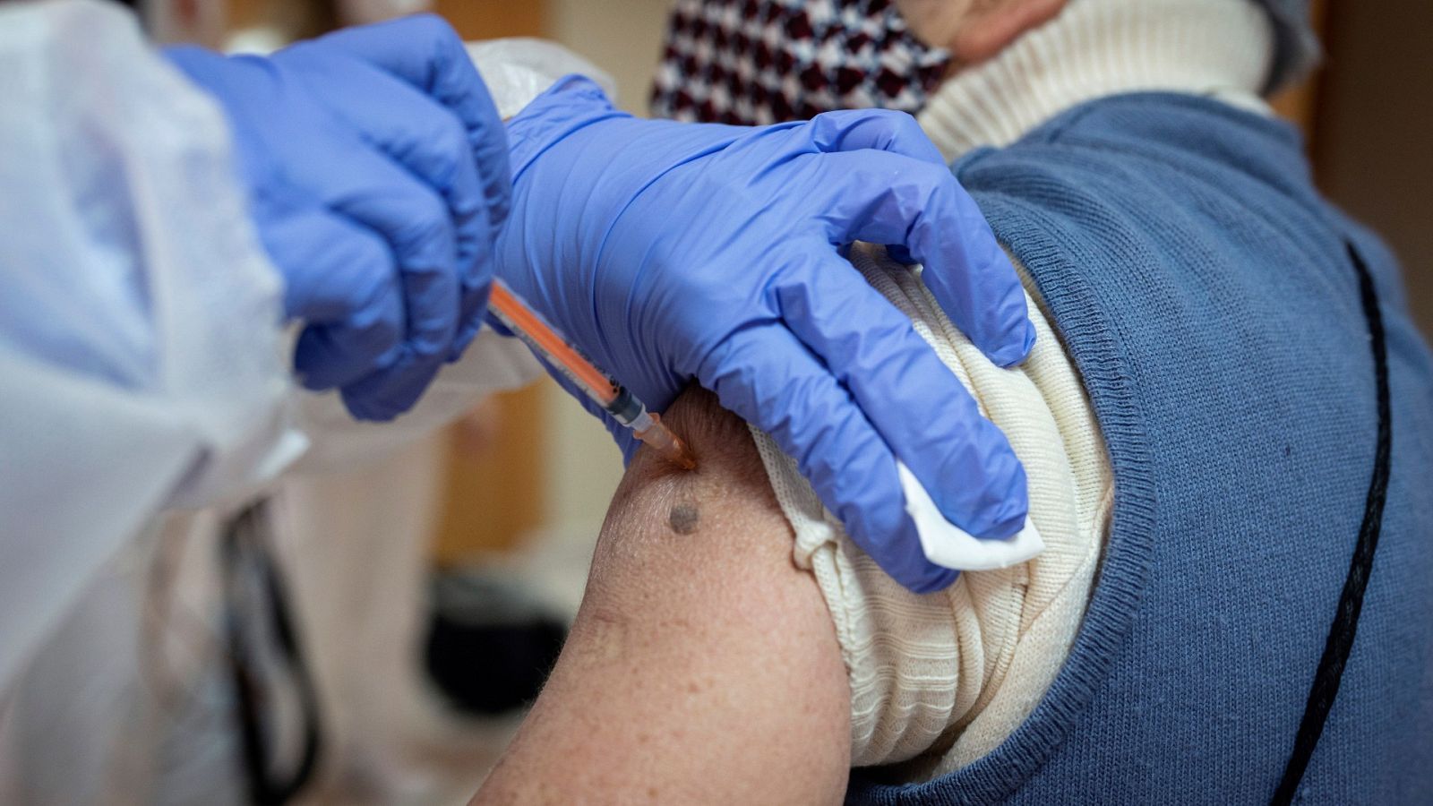 Un usuario de una residencia de Alcalá de Henares (Madrid) recibe una dosis de la vacuna contra el covid