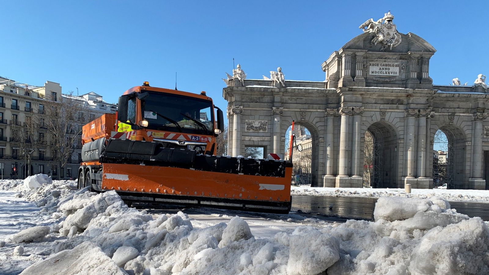 Una máquina quitanieves realiza labores de limpieza junto a la Puerta de Alcalá.