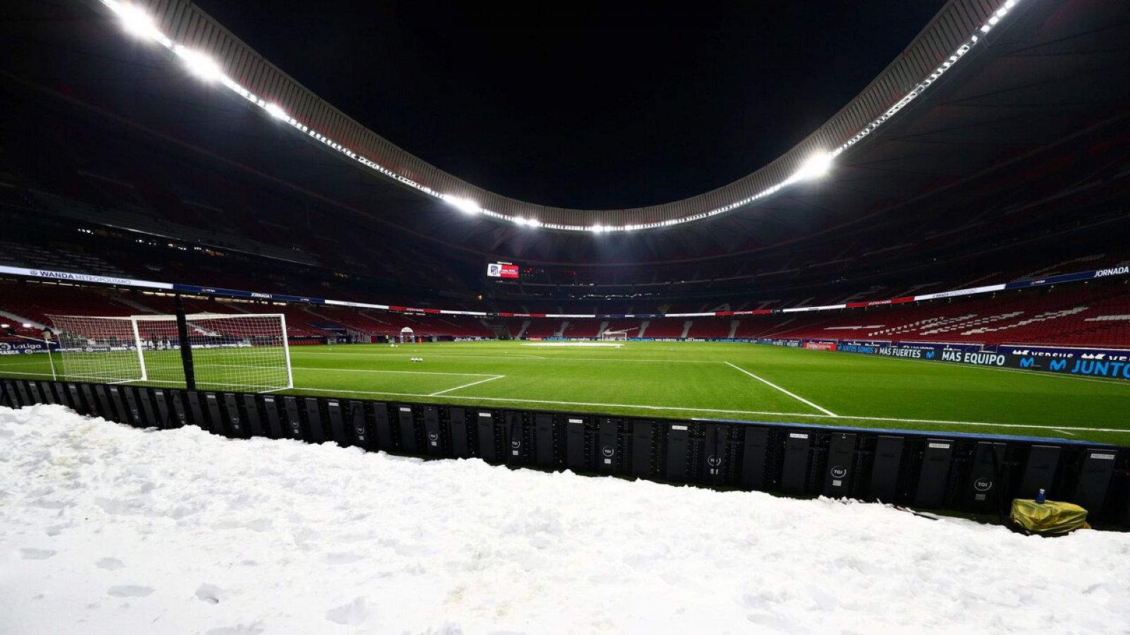 Vista del césped del Wanda Metropolitano con la nieve en un fondo.