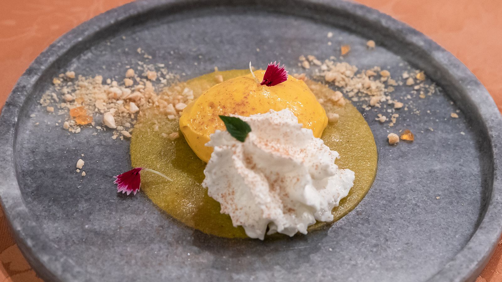 Espuma de yogurt, helado de mango, gelatina de fruta de la pasión y almendra caramelizada