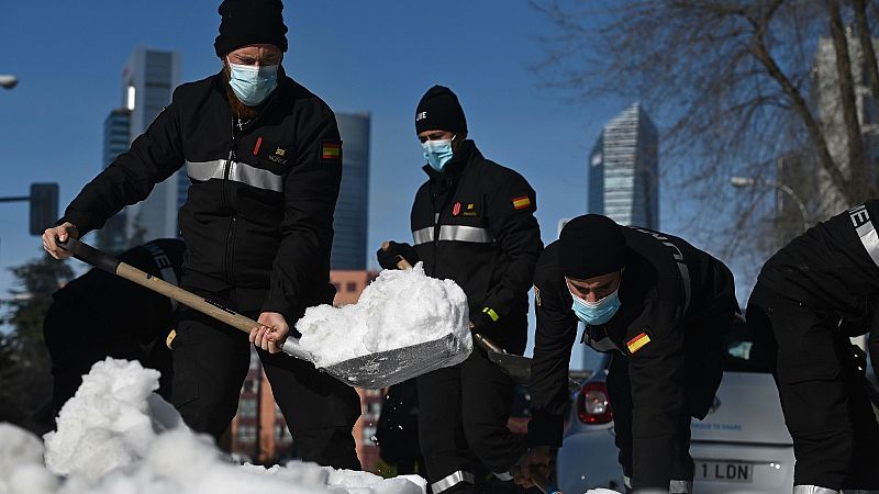 Varios efectivos limpian una calle tras las fuertes nevadas causadas por el temporal Filomena en Madrid.