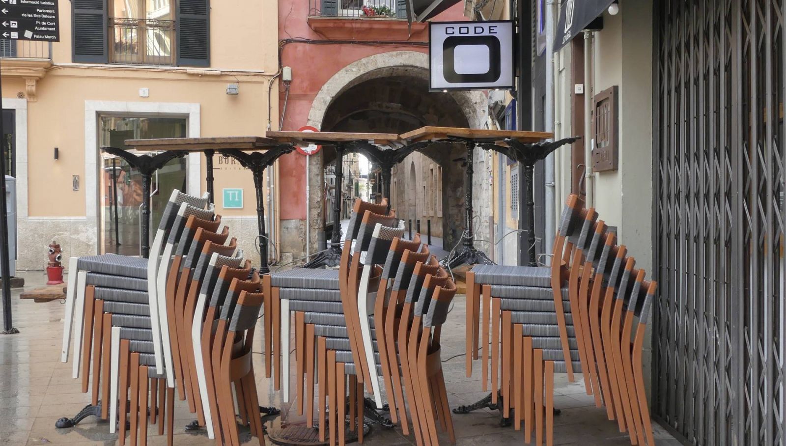 Mesas apiladas junto a un bar cerrado en Palma de Mallorca