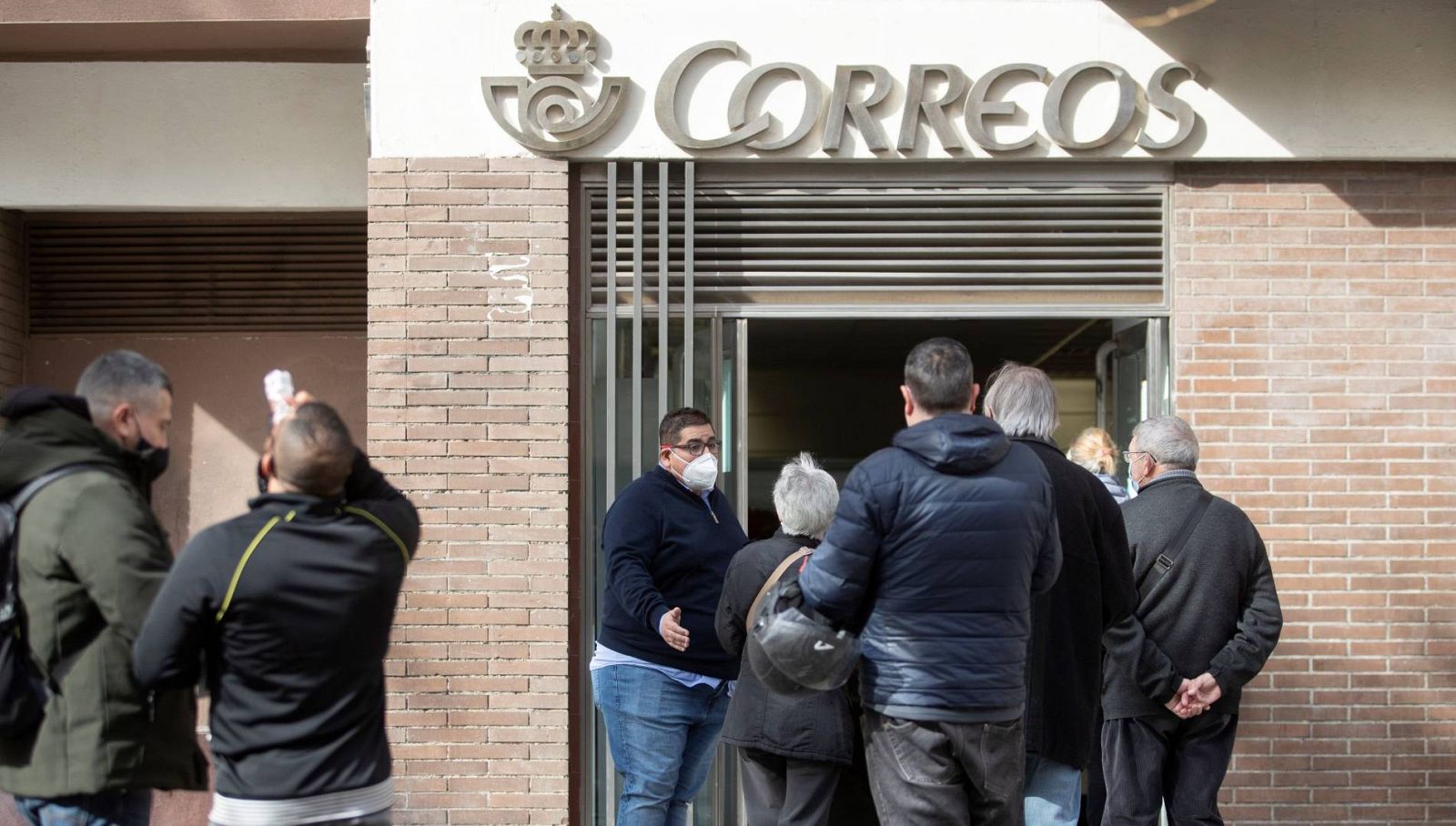 Varias personas hacen cola en una oficina de Correos de Barcelona este viernes