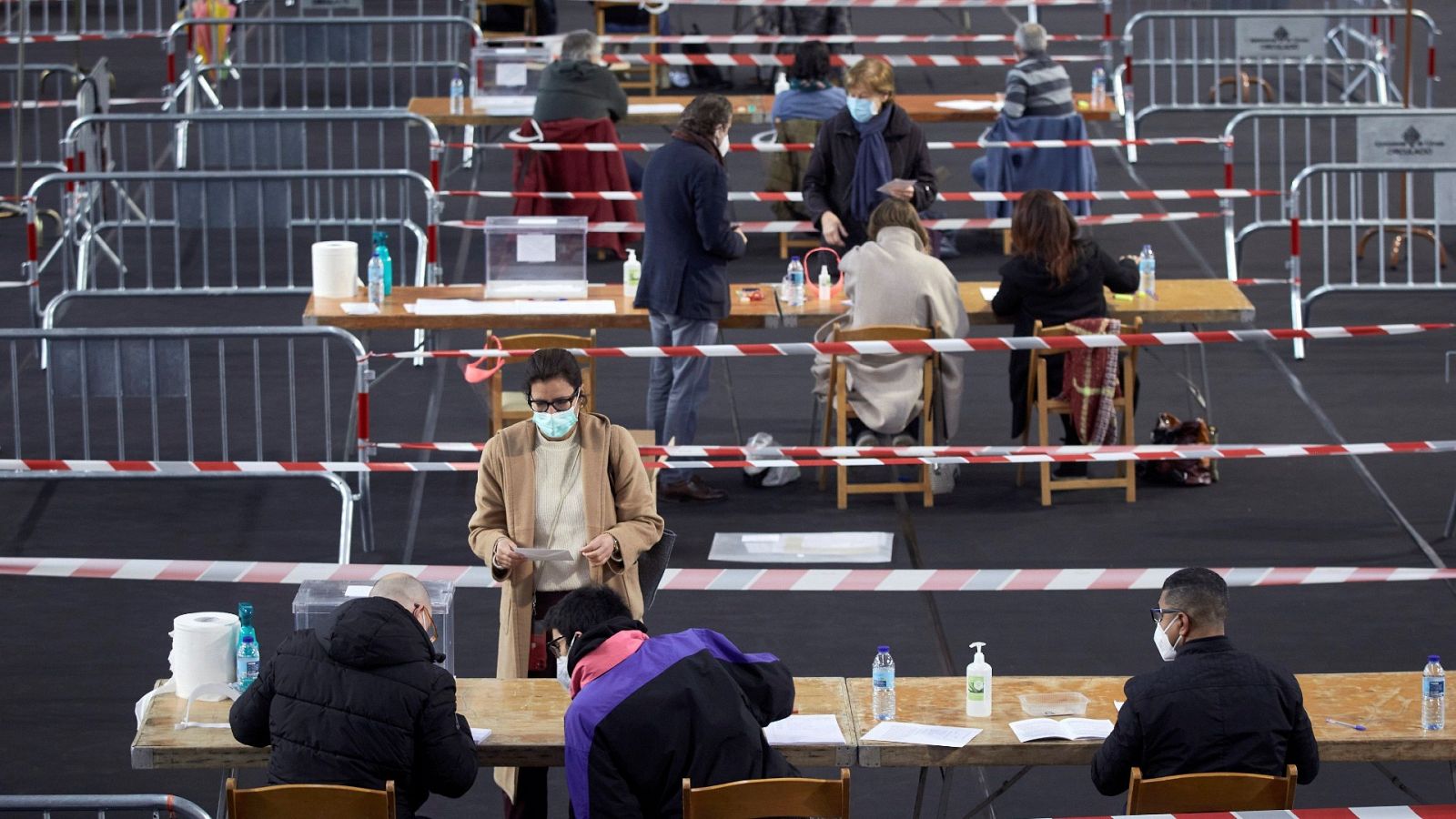 Varias personas votan en el colegio electoral del polideportivo municipal de Palau en Girona