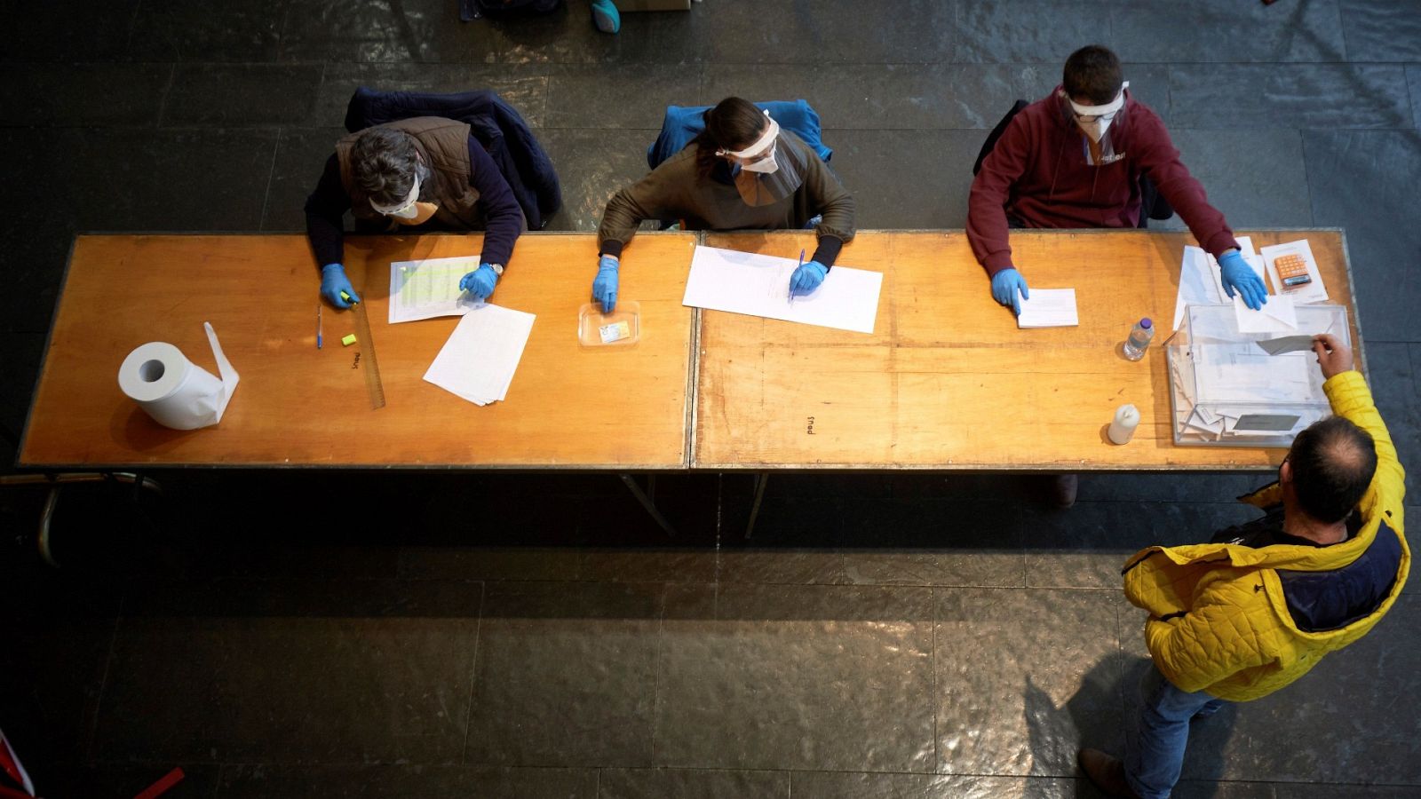 Un hombre ejerce su derecho al voto para las elecciones al Parlament del 14F en el polideportivo de Fontajau, de Girona.