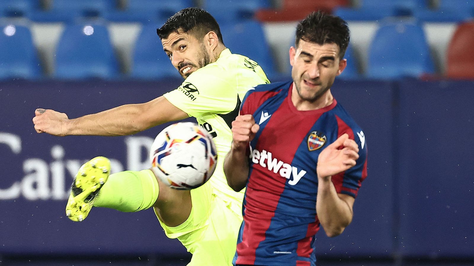 Suárez (i) golpea el balón ante la oposición de Postigo, del Levante