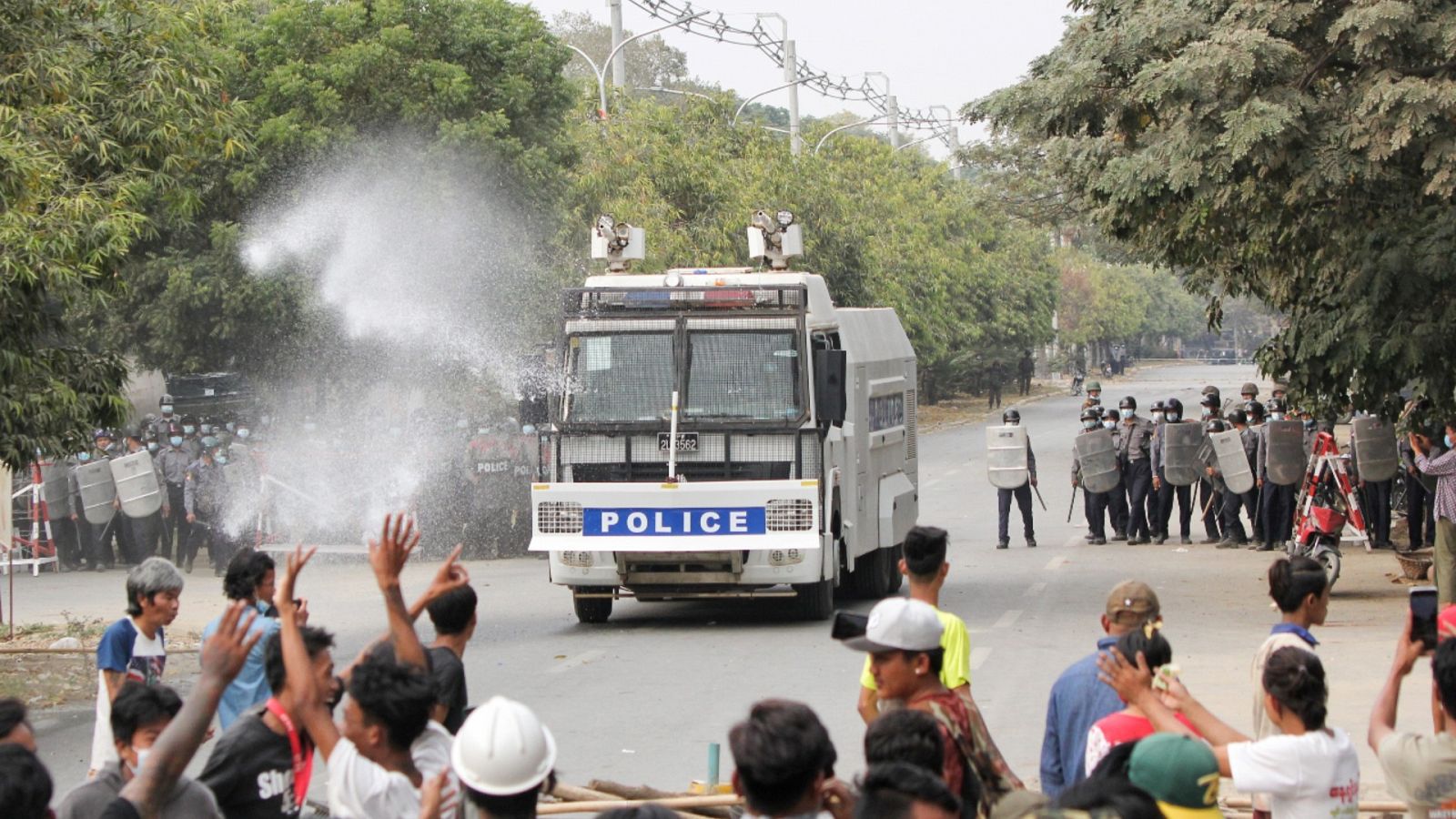 Imagen del 20 de febrero de 2021 de agentes de policía frente a personas que protestaban en Mandalay, Birmania, contra el golpe de Estado perpetrado a principios de mes por la Junta militar.