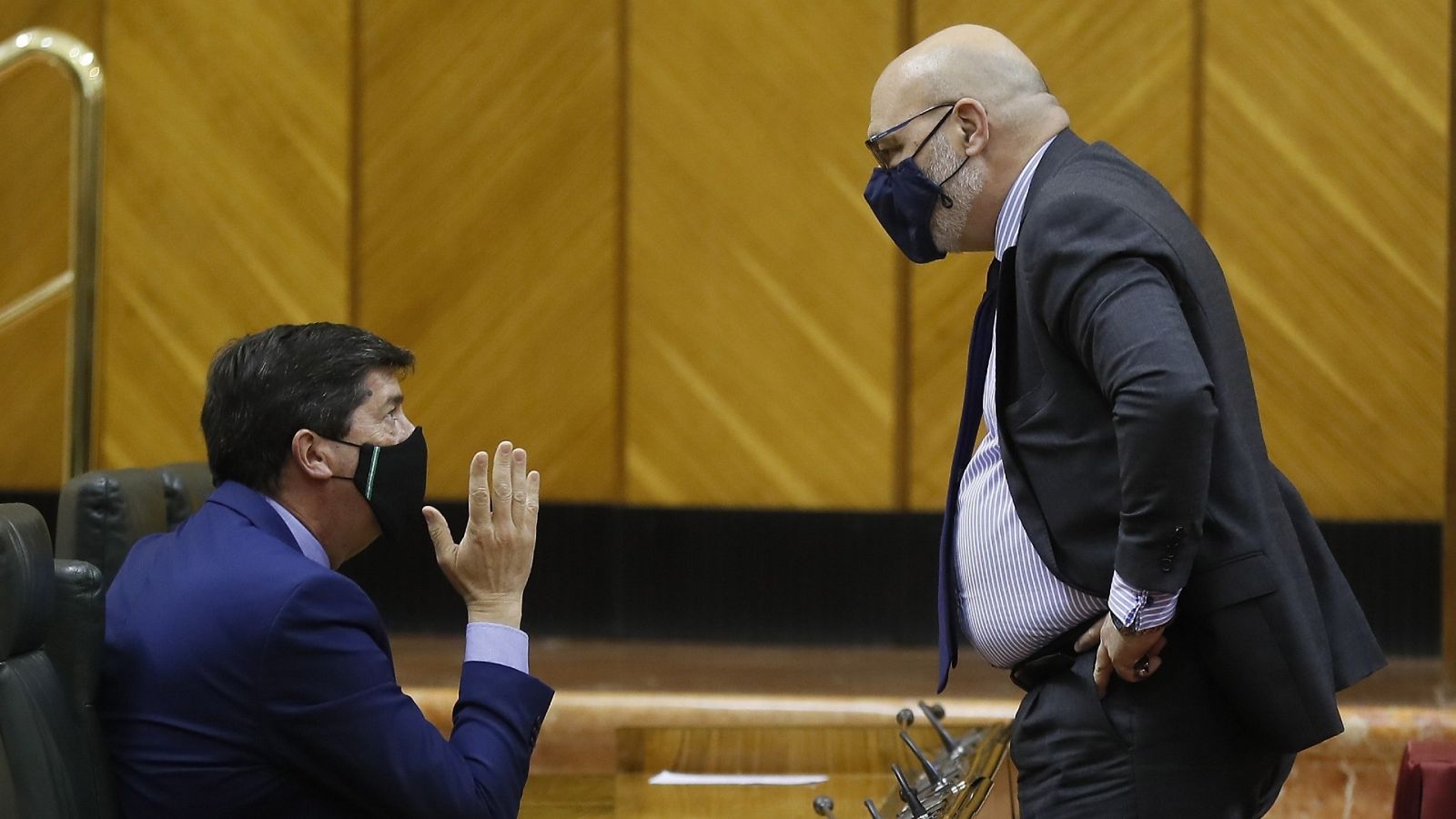 El vicepresidente de la Junta de Andalucía, Juan Marín (Cs), conversa con el portavoz parlamentario de Vox, Alejandro Hernández, este jueves en el Parlamento andaluz.