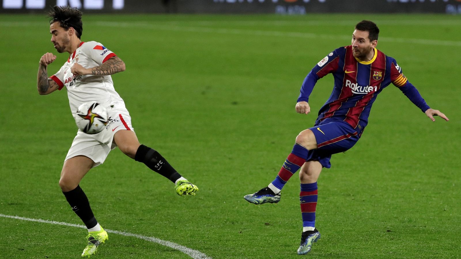 Leo Messi, jugador del FC Barcelona dispara a puerta con Suso, del Sevilla, intentado interferir el balón