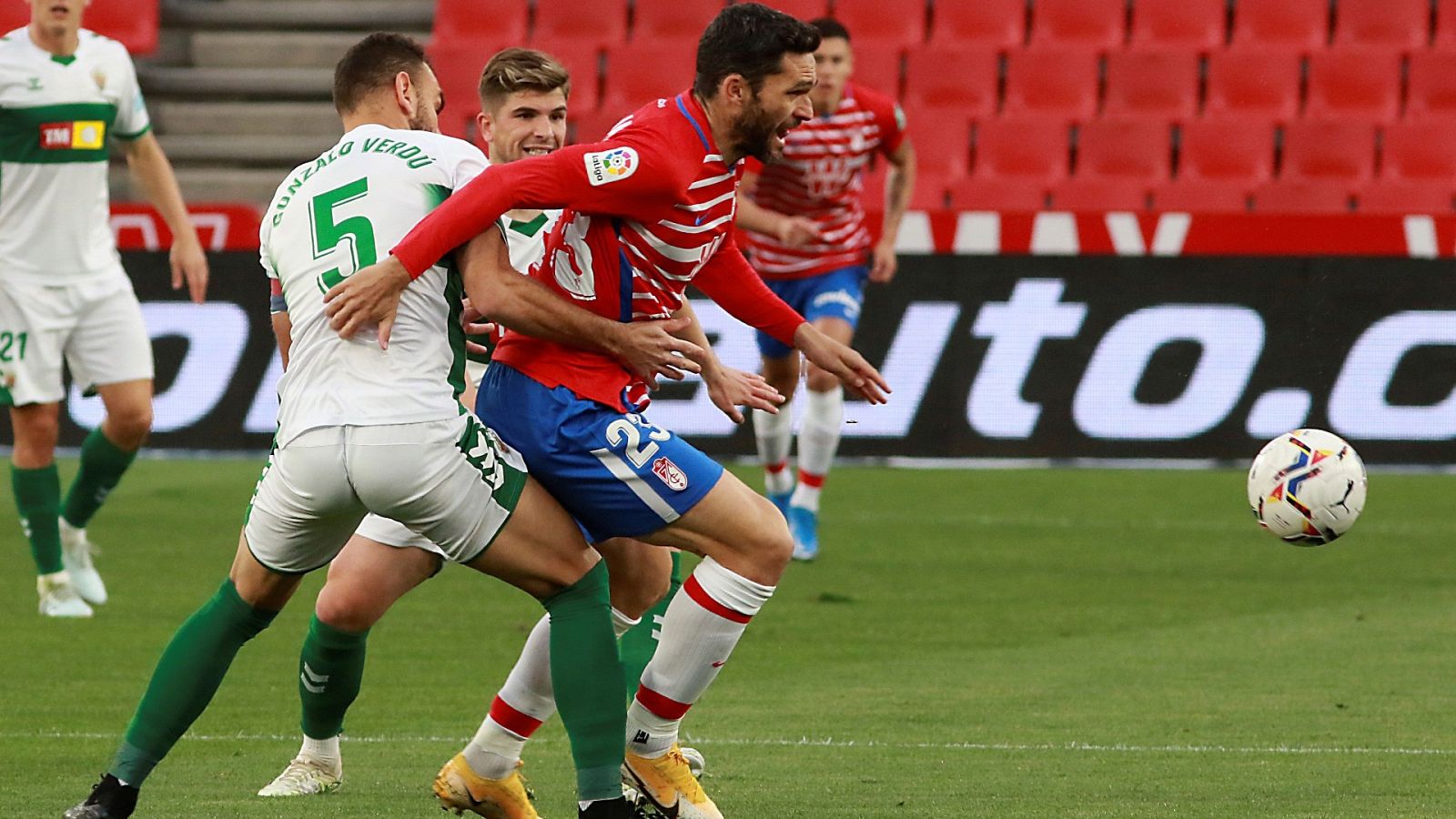 El defensa del Elche Gonzalo Verdú (i) pelea un balón con el delantero del Granada Jorge Molina