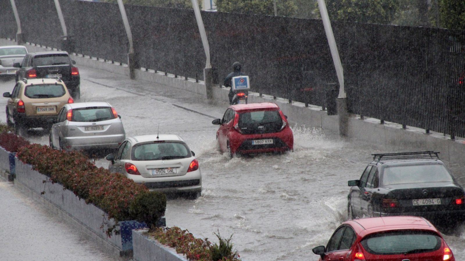 Imagen de varios coches bajo la intensa lluvia en una calle de la ciudad autónoma de Ceuta.