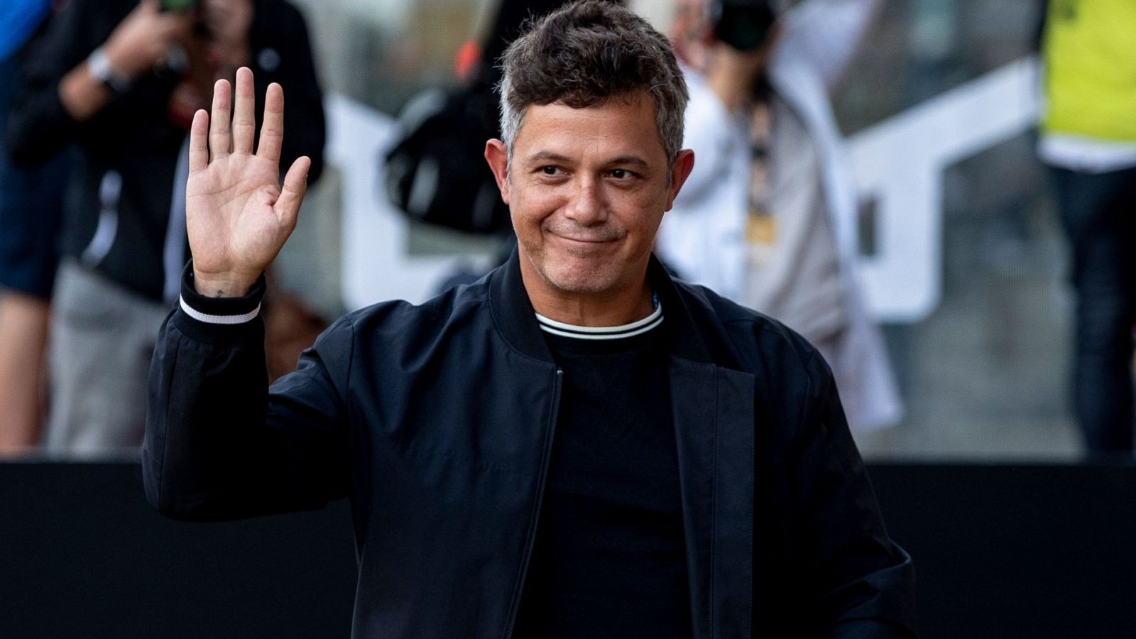 Alejandro Sanz saluda con la mano vestido de negro