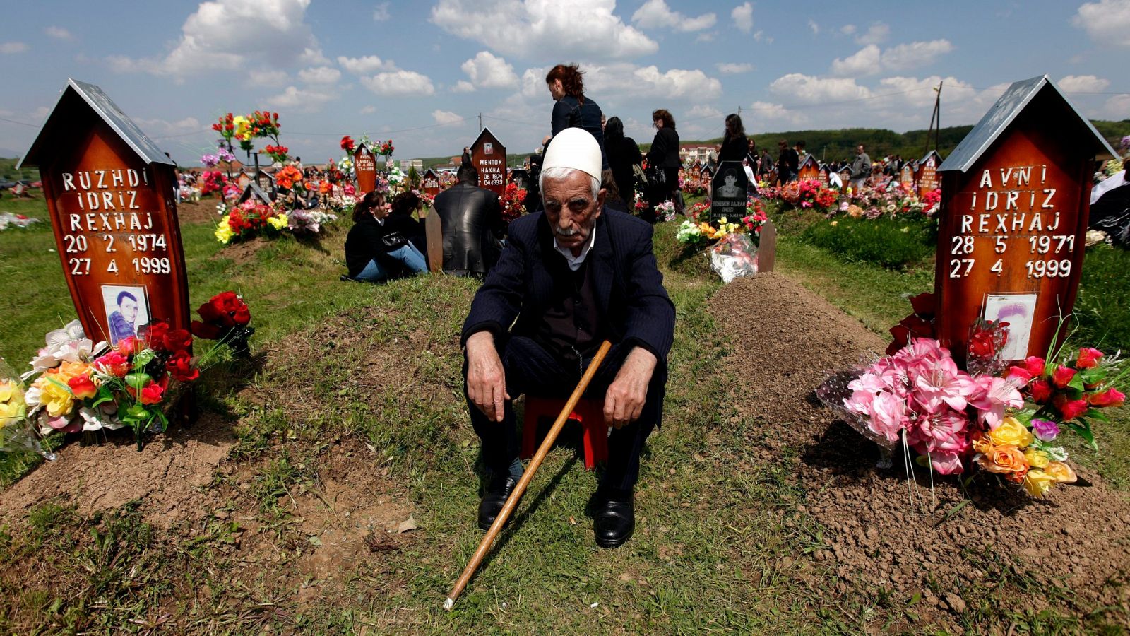 Un hombre posa frente a la tumba de sus hijos muertos a manos del ejército serbio