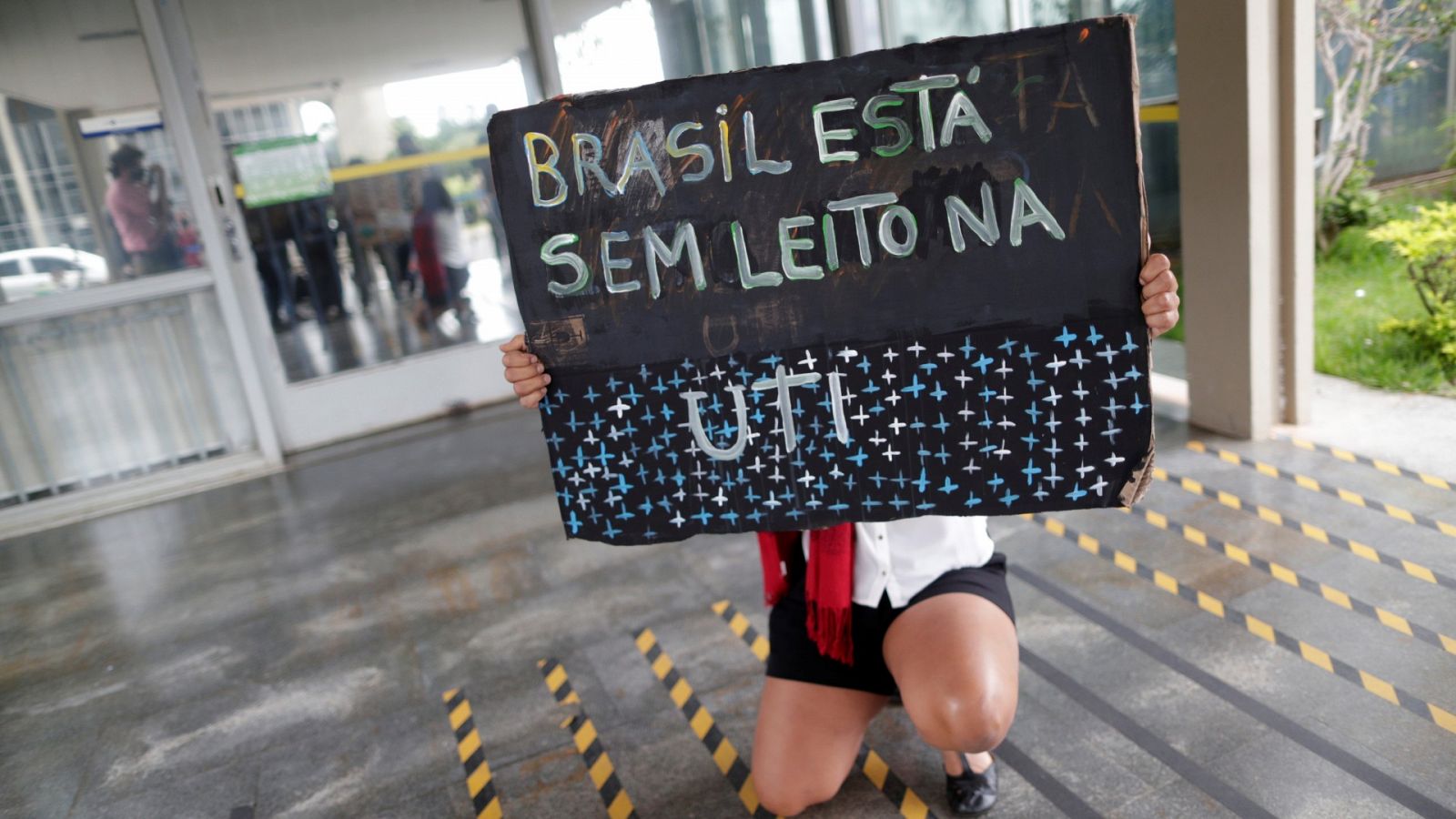 Una mujer sostiene un cartel que dice "Brasil no tiene camas en la UCI" mientras protesta contra las políticas de salud del gobierno de Brasil, en la sede del Ministerio de Salud en Brasilia, Brasil, el 16 de marzo de 2021.