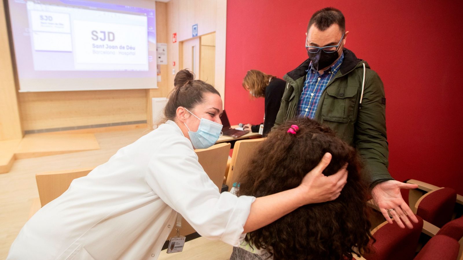 La nefróloga del Hospital Sant Joan de Déu Yolanda Calzada juega con Candela ante la mirada de su padre.