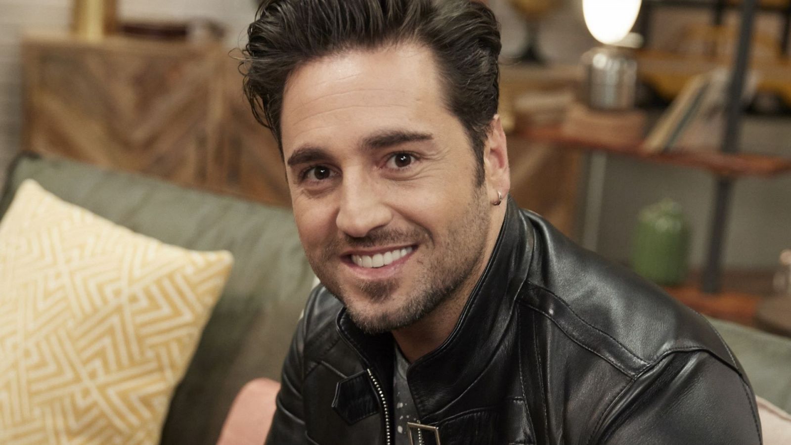 David Bustamante sonríe a cámara con una chaqueta de cuero negra