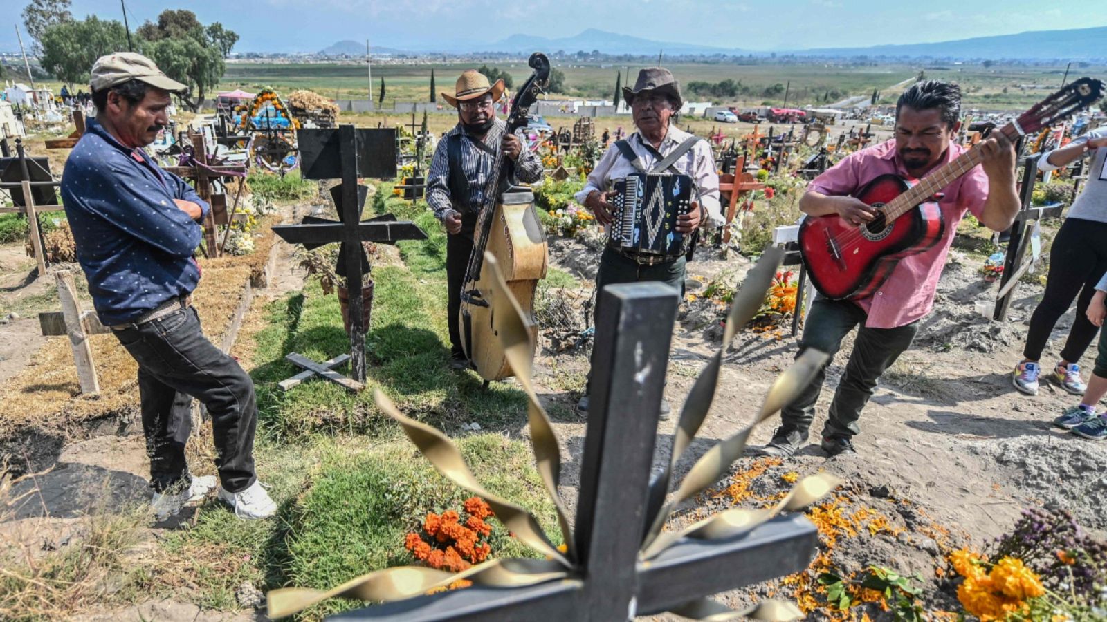 Imagen de archivo del 28 de octubre de 2020 de tres hombres tocando música con varios instrumentos ante la tumba de una víctima de la COVID-19 en el Panteón Municipal del Valle de Chalco, Estado de México.