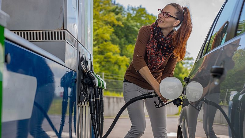 Una mujer repostando combustible