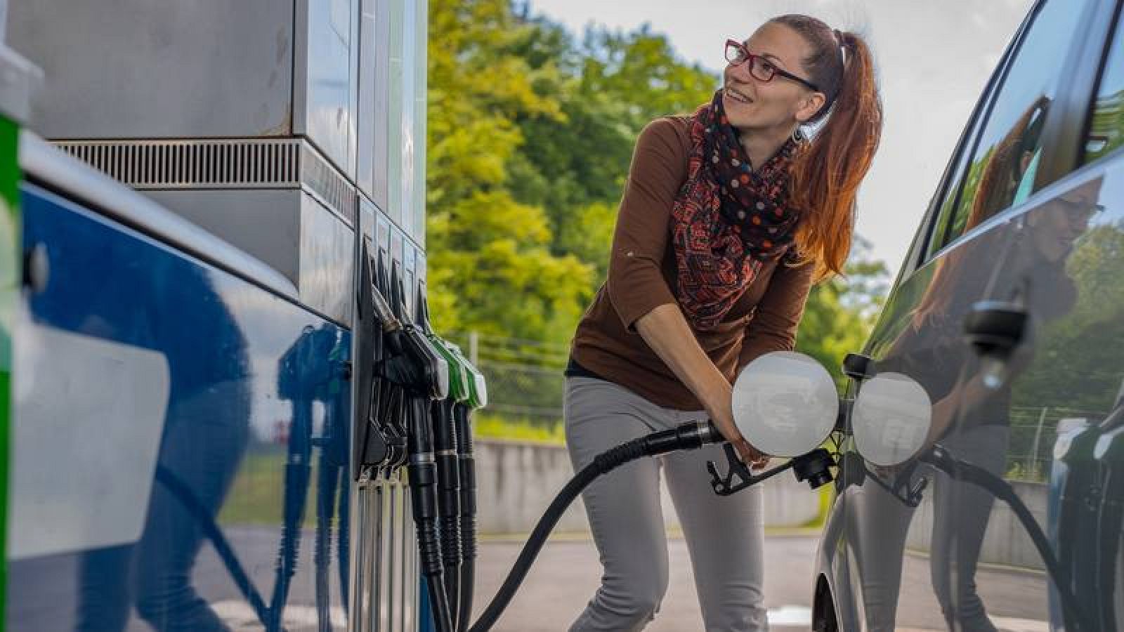 Una mujer repostando combustible