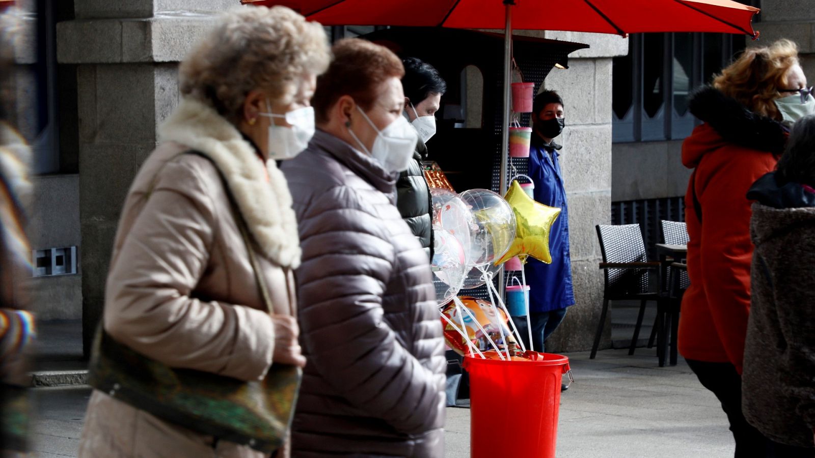 Varias personas con mascarilla caminan por una calle en Lugo