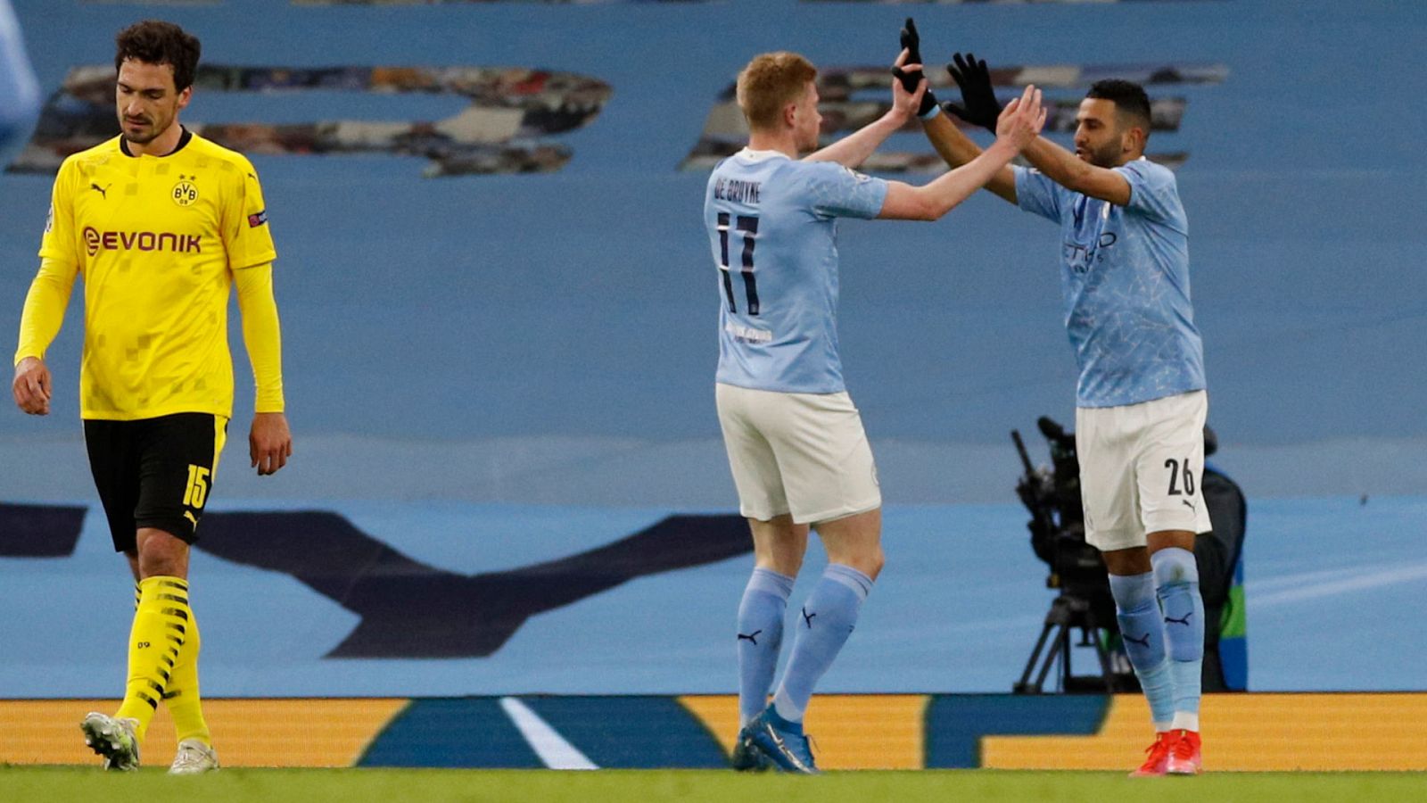 Kevin De Bruyne (centro), felicitado por un compañero del City tras marcar al Dortmund. A la izquierda, un cabizbajo Hummels