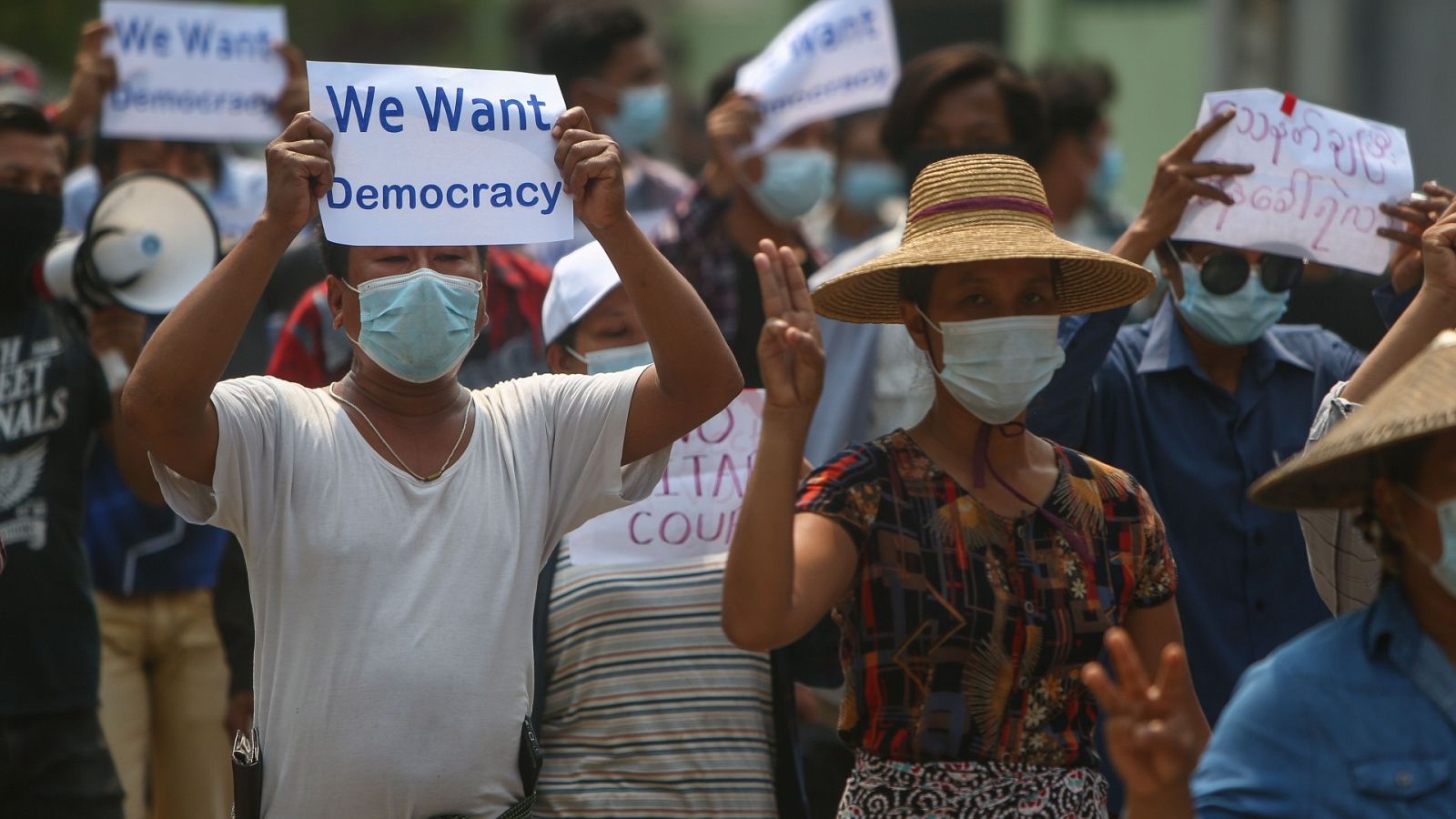 Los manifestantes saludan con tres dedos y llevan pancartas que piden la democracia durante una protesta antimilitar en Mandalay, Myanmar, el 26 de abril de 2021