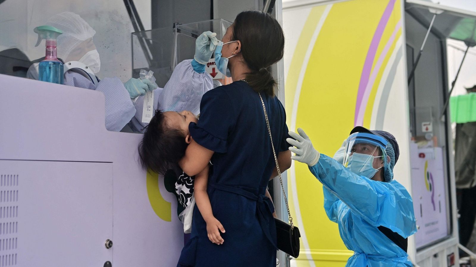 Un médico realiza una preba nasal a una mujer en Bon Kai una de las áreas con el mayor número de casos positivos de coronavirus