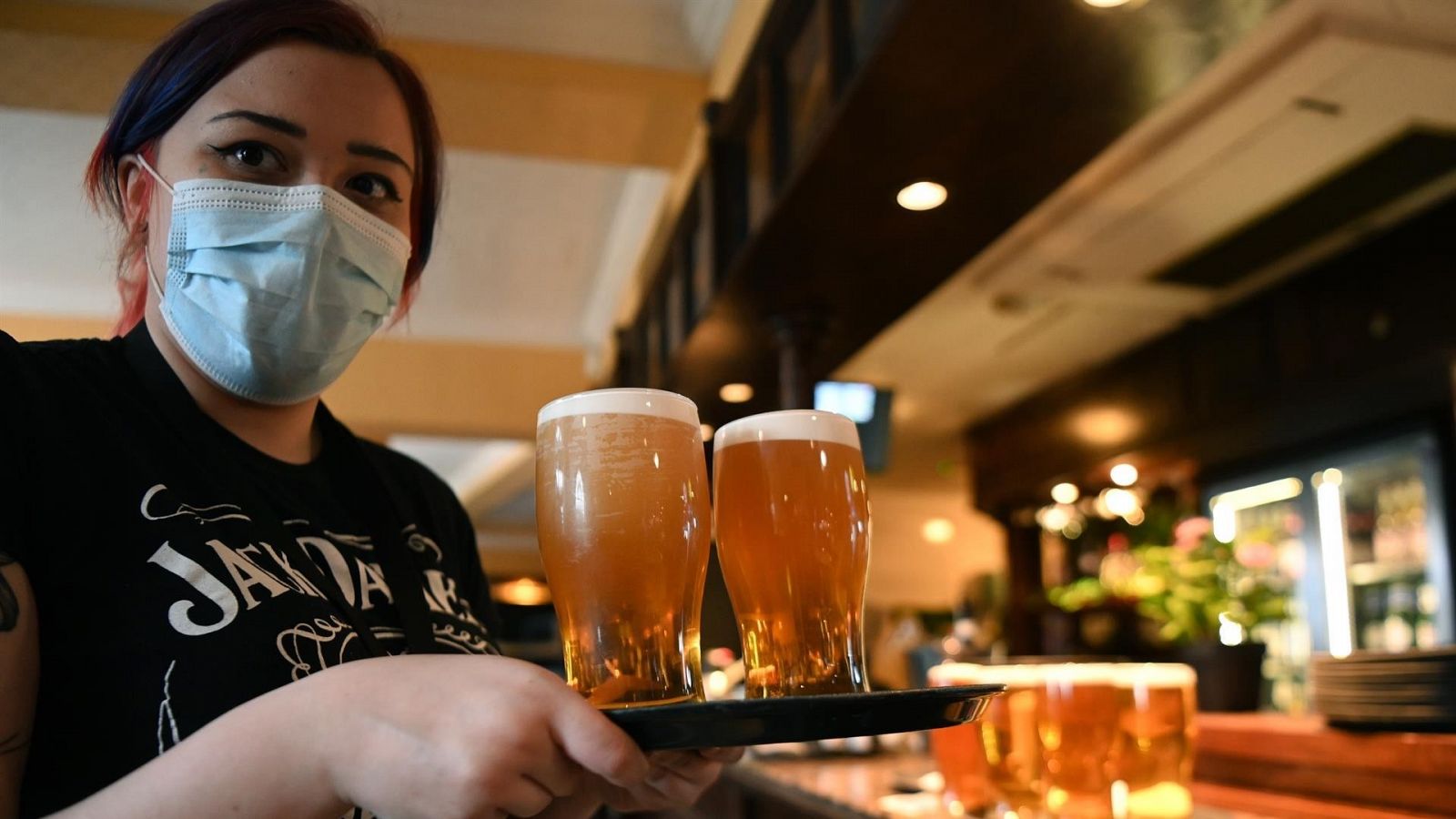 Una camarera con mascarilla en el interior de un restaurante