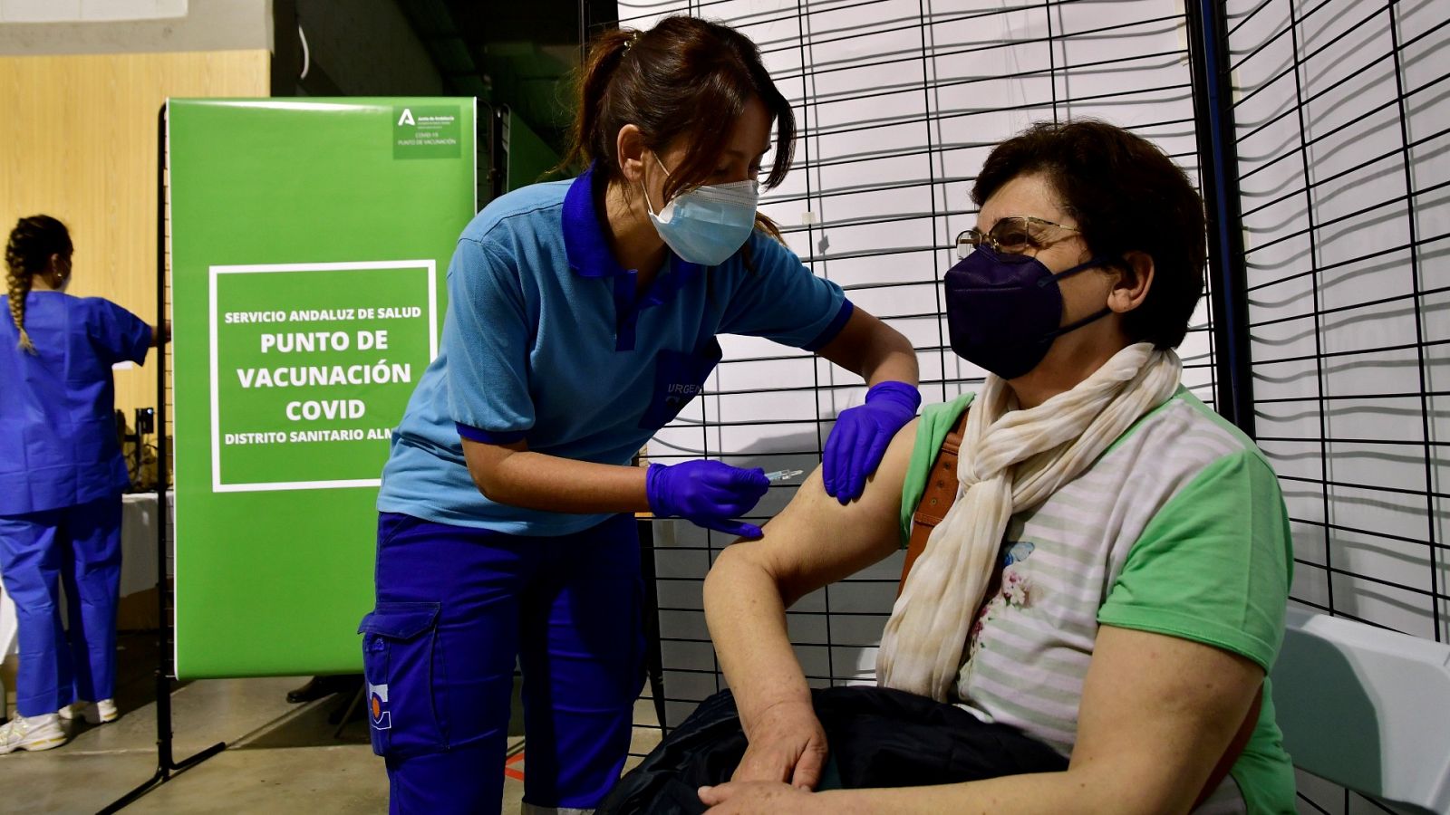 Una enfermera pone la vacuna de Janssen a una mujer en el punto de vacunacion masiva en el Palacio de los Juegos del Mediterráneo de Almería.