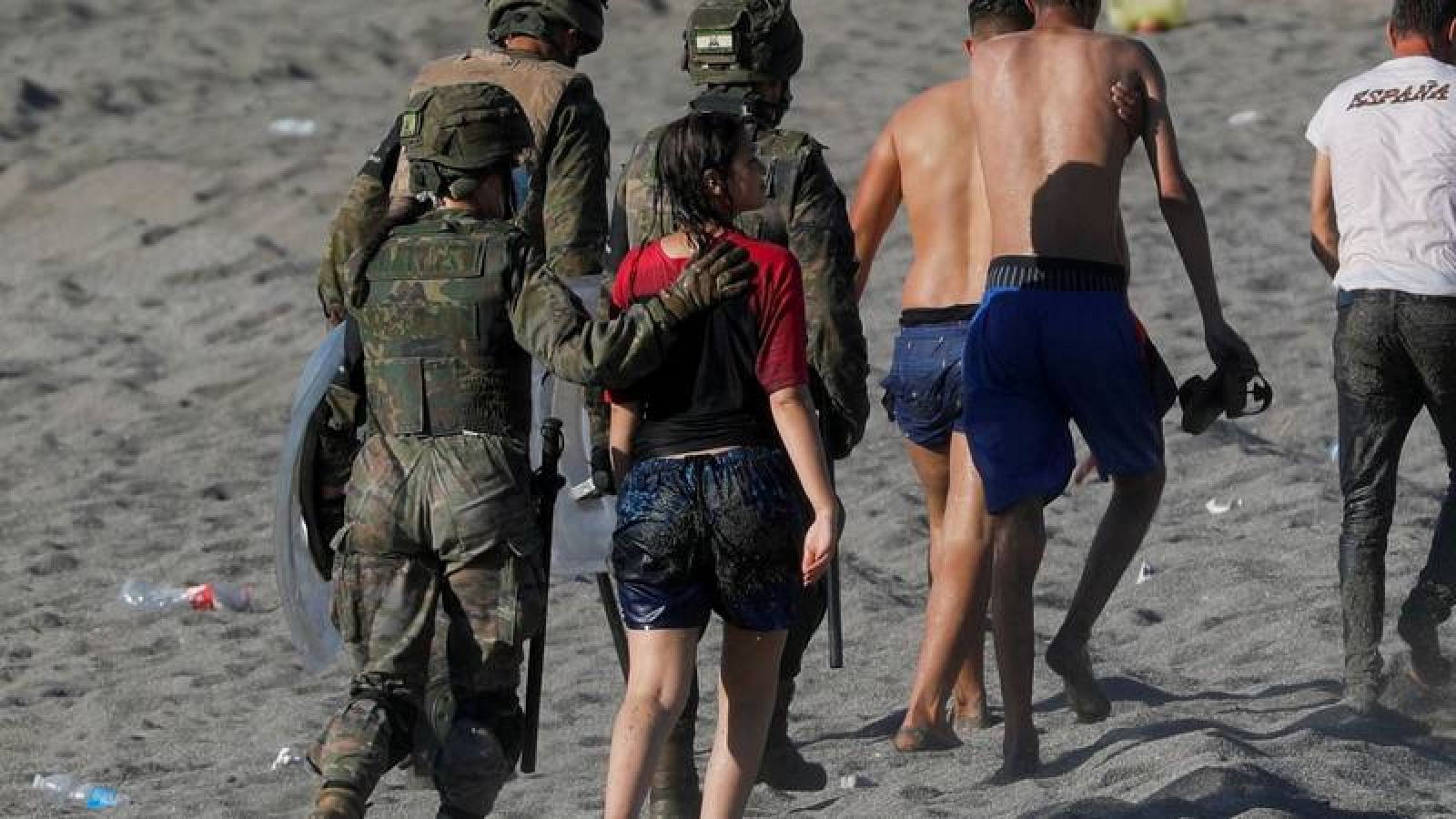  Varios migrantes son escoltados a la frontera tras entrar en Ceuta