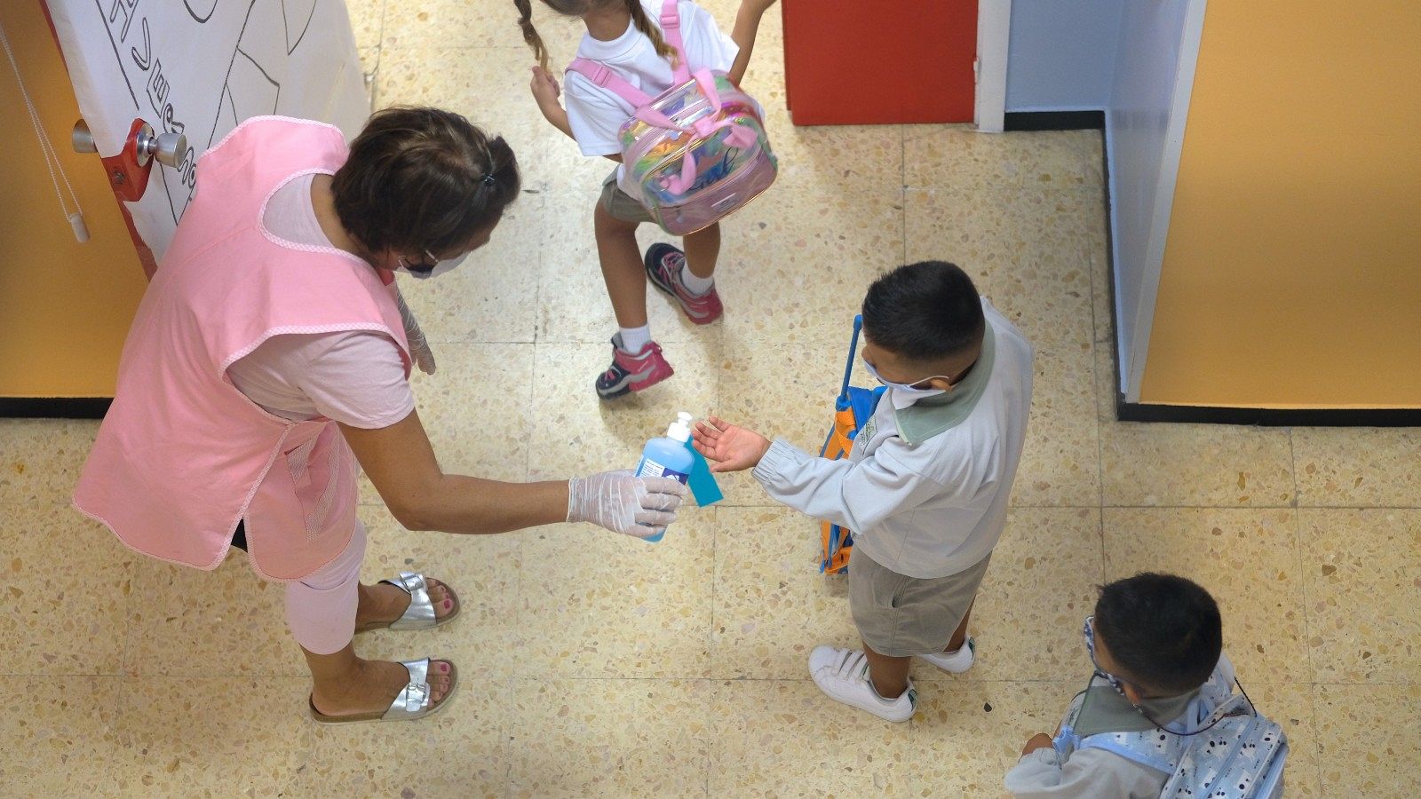 Una profesora pone gel desinfectante en las manos a un niño en el colegio Millares Carló de Puerto del Rosario (Fuerteventura).
