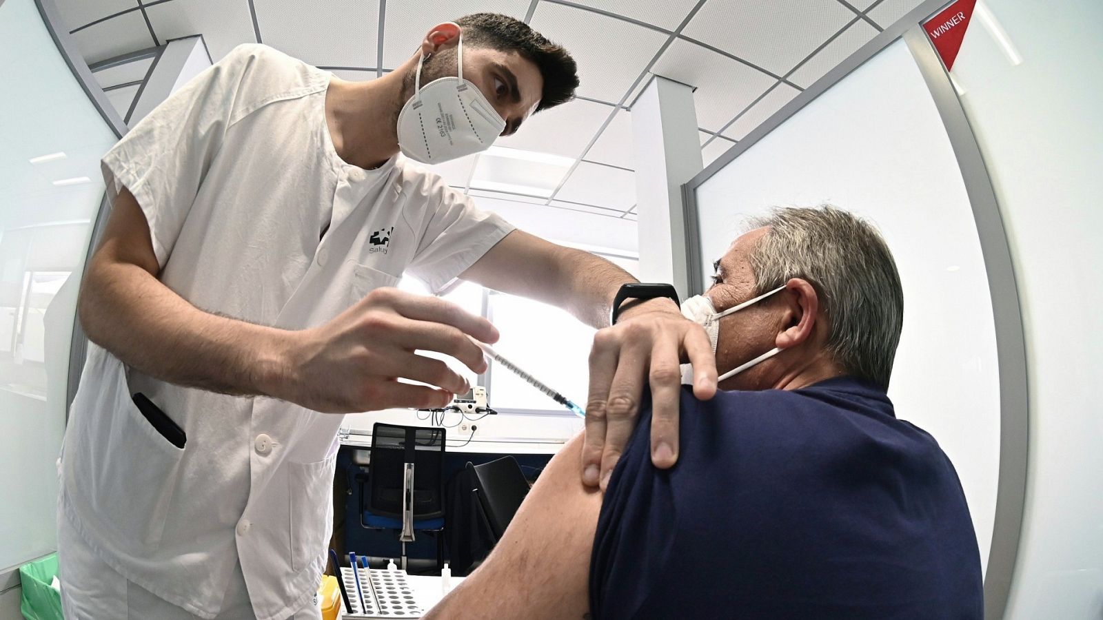 Un sanitario vacuna contra el coronavirus a un hombre en el hospital de Alcalá de Henares en Madrid,