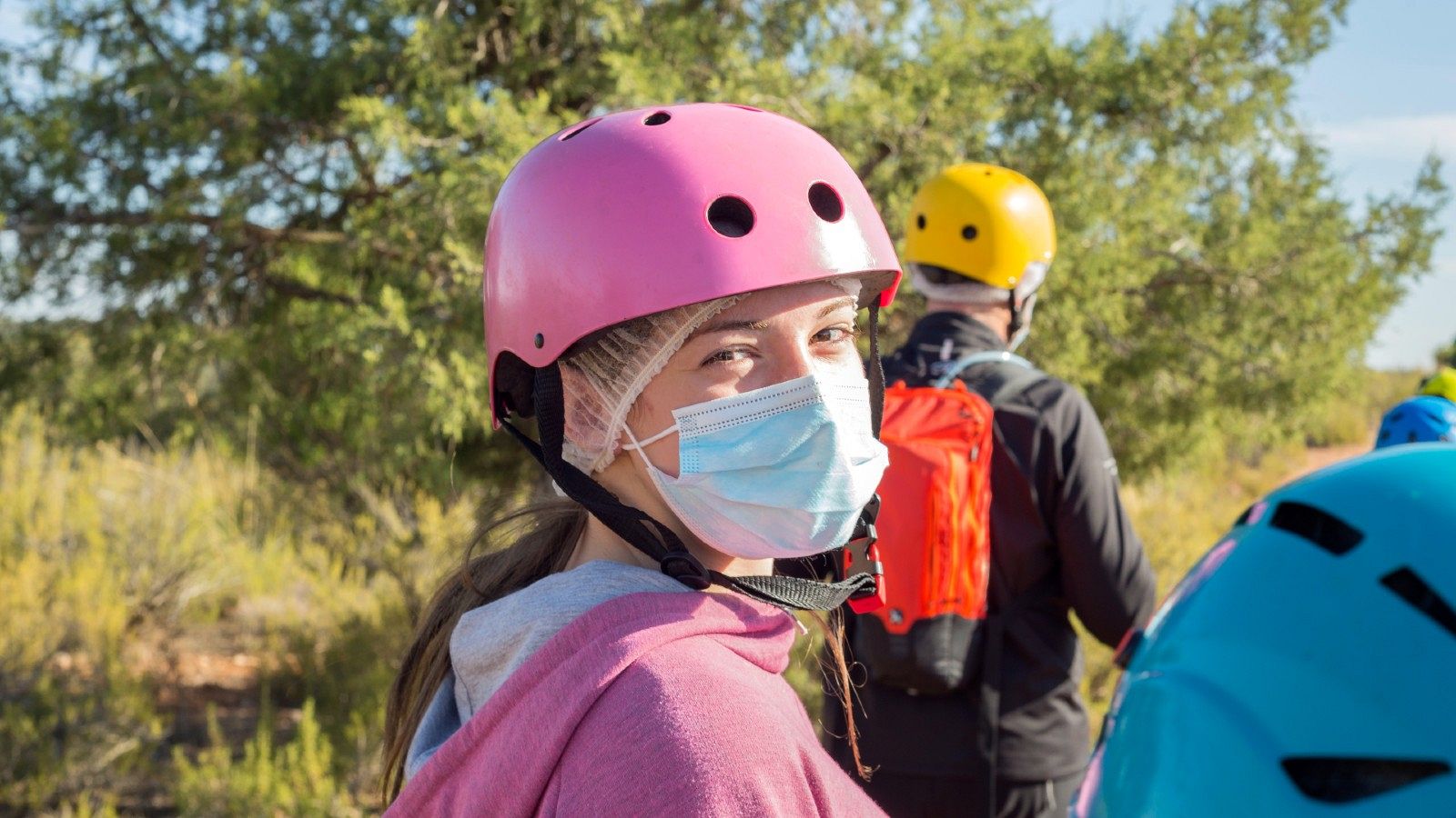 Una niña participa en una actividad al aire libre con mascarilla.