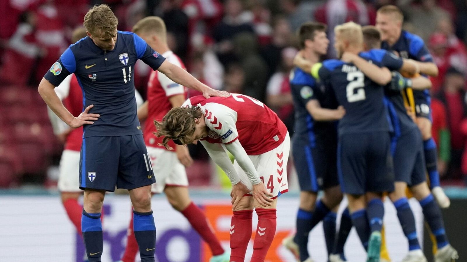 Los jugadores de Finlandia consuelan a los de Dinamarca tras el partido en Copenhague.