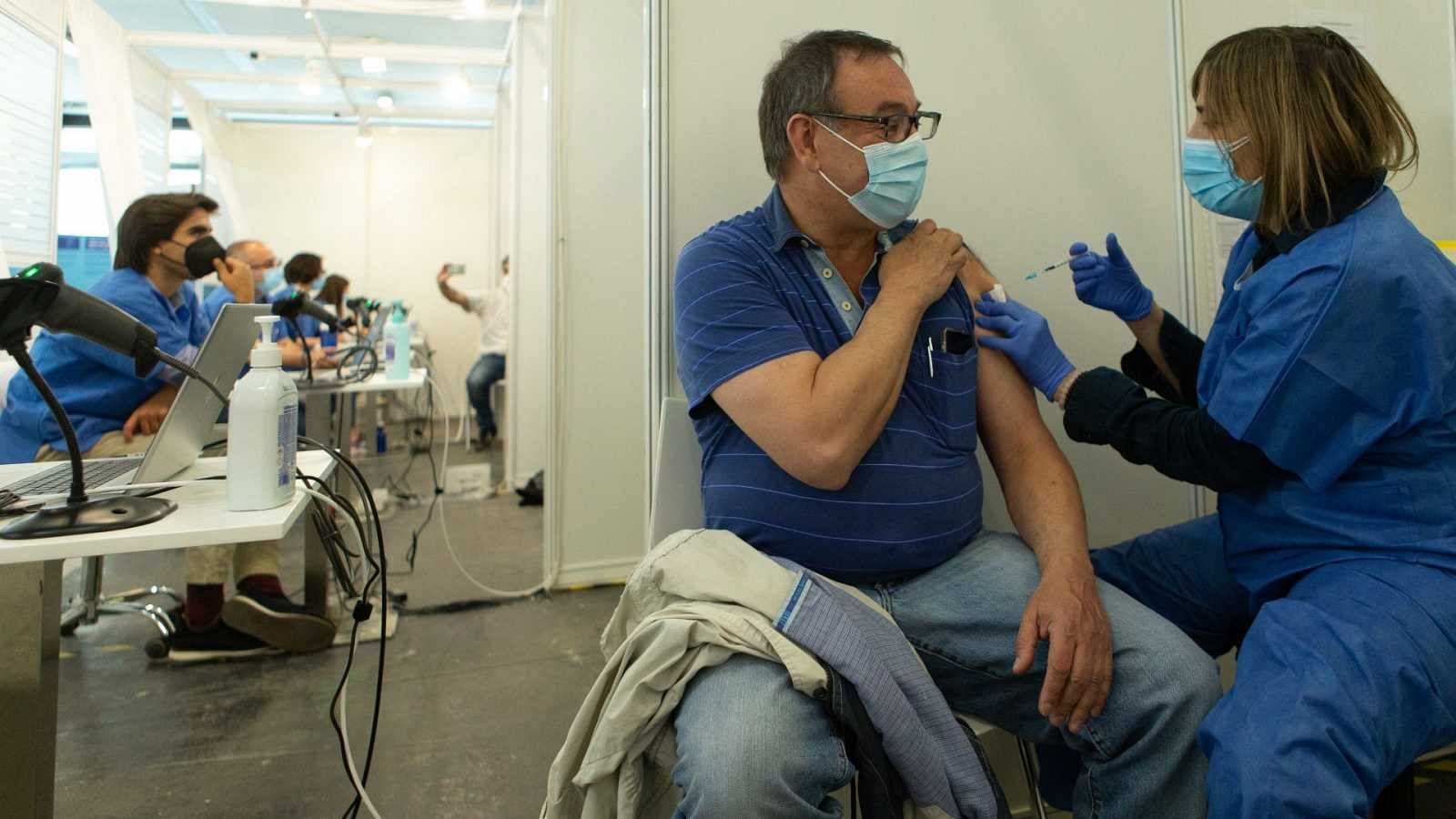 Una enfermera vacuna a un hombre contra la COVID-19 en el centro de vacunación de la Fira de Barcelona.