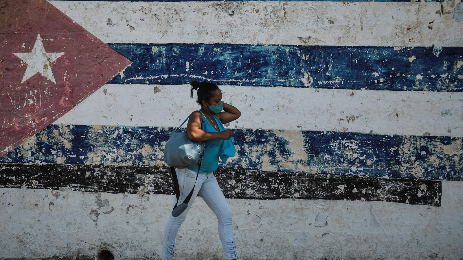 Una mujer camina por una calle de La Habana, Cuba