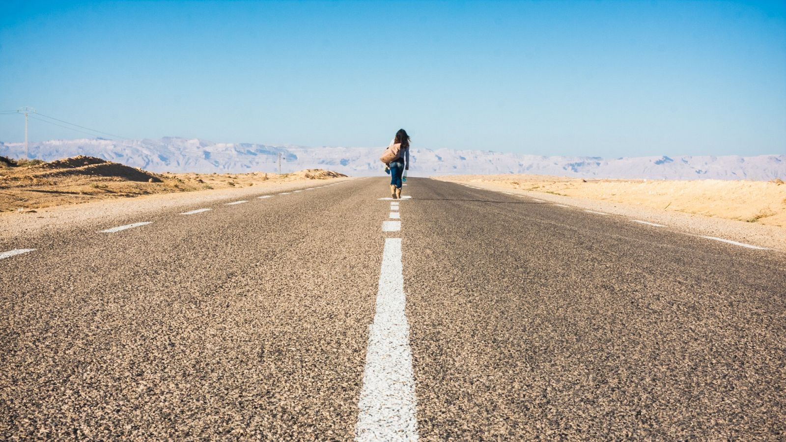 Una mujer caminando en una carretera en el sur de Túnez