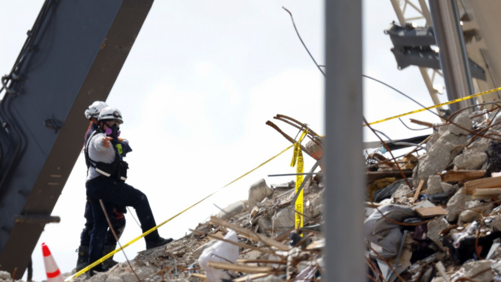 Una imagen de dos rescatistas sobre los escombros de una parte del 
del edificio Champlain Towers South en Surfside, Miami.