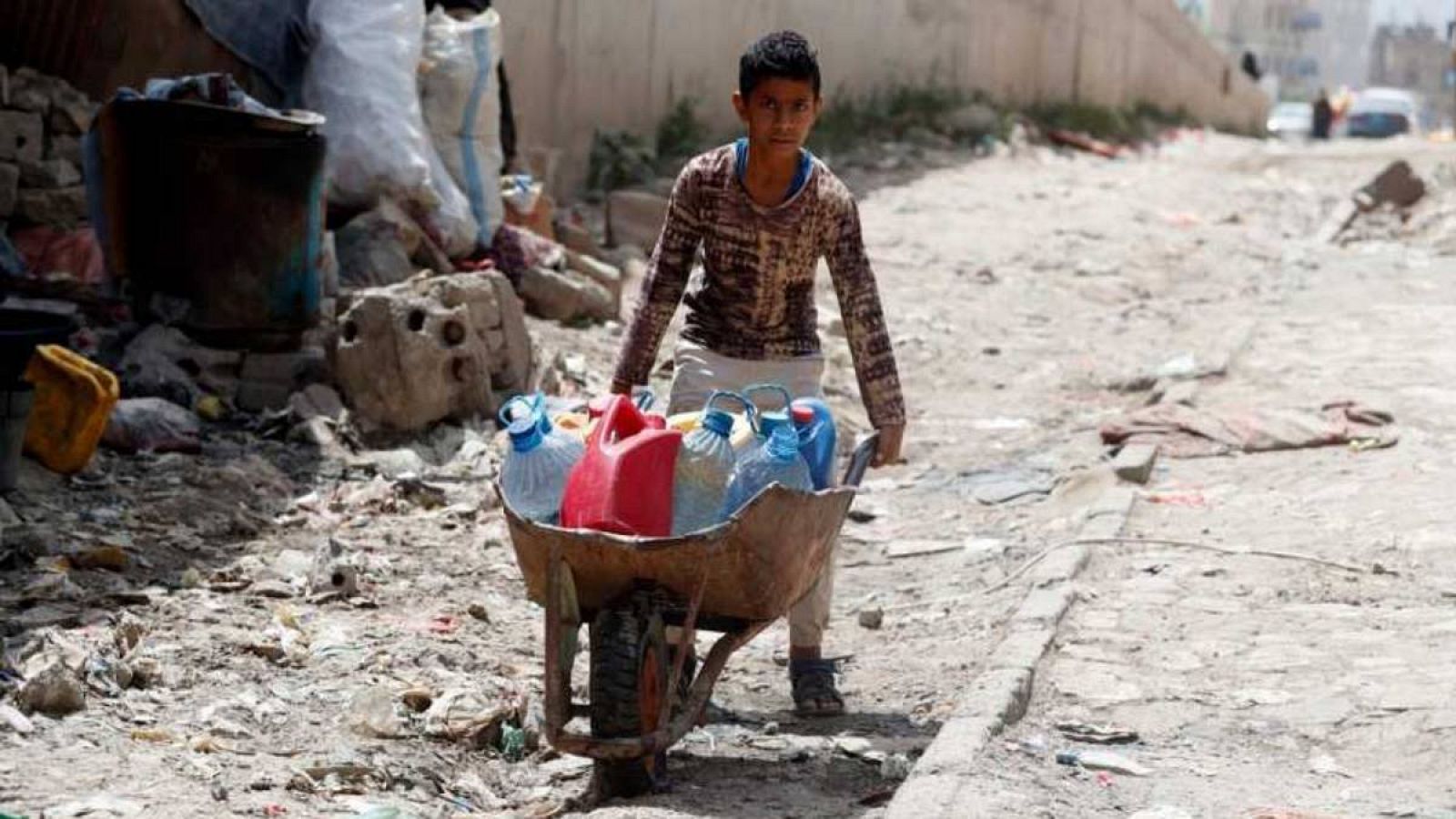 Un niño empujando una carretilla con botellas llenas de agua en Saná, Yemen.