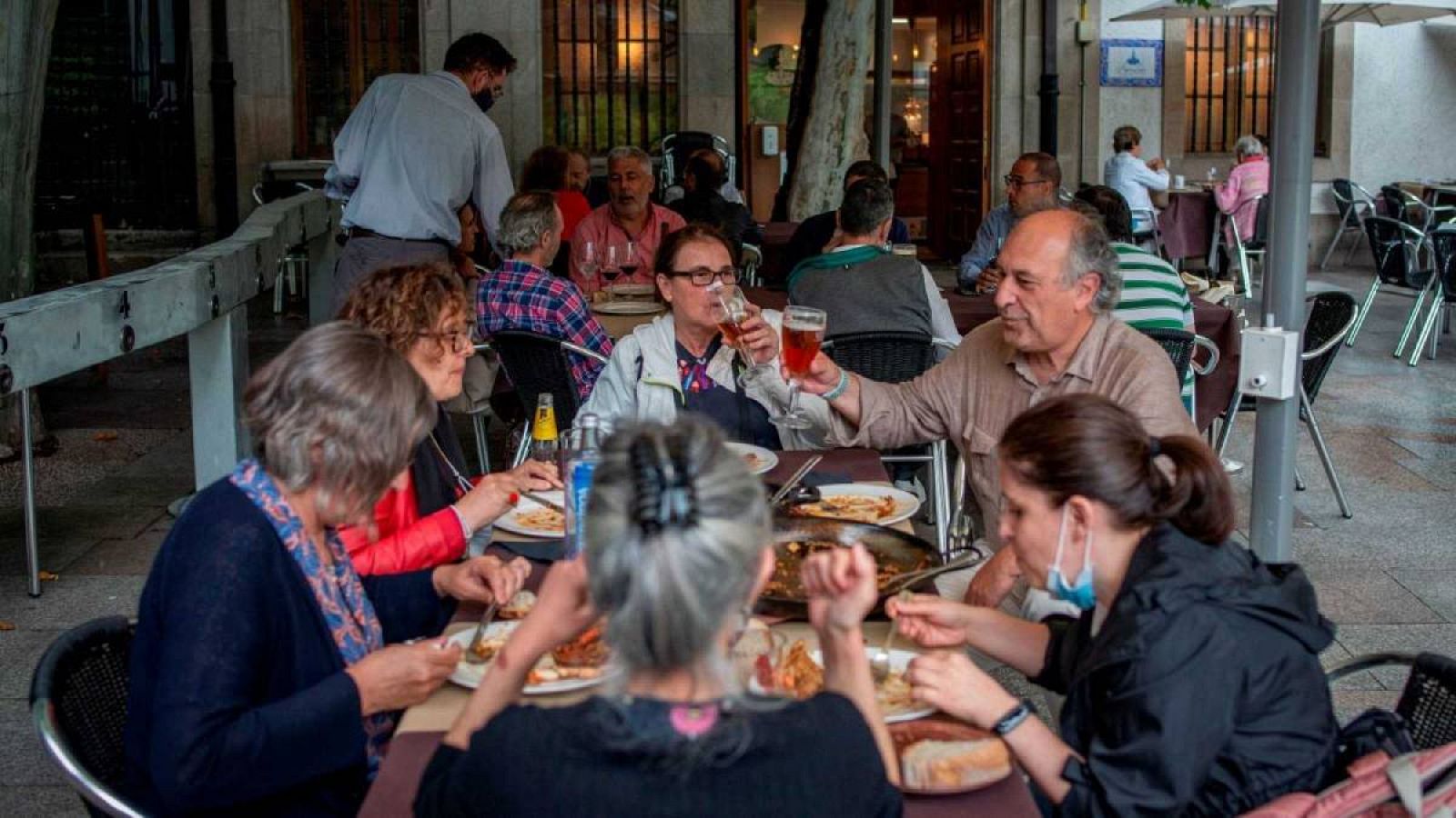 Un grupo de personas come en la terraza de un restaurante de Orense. 