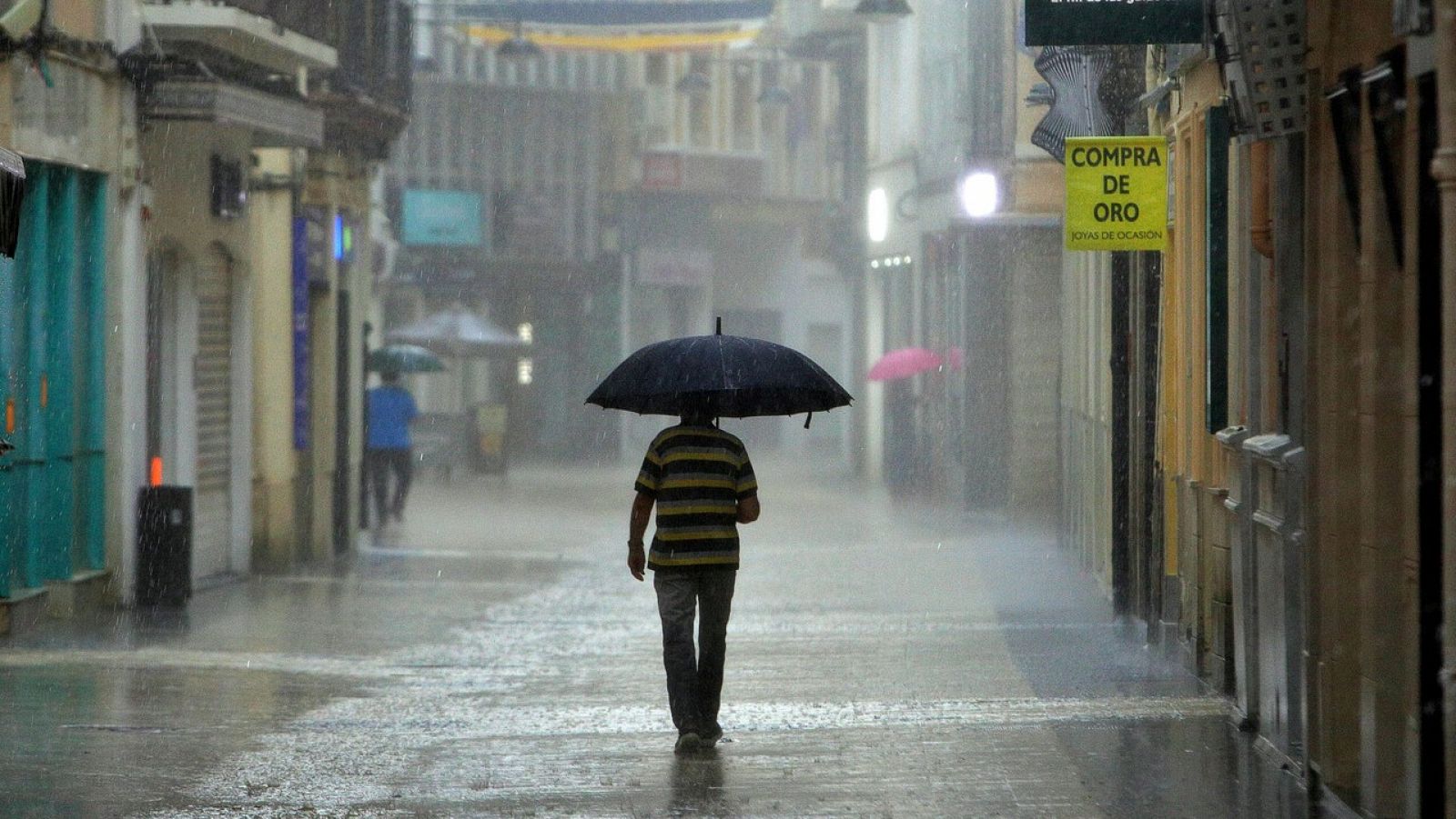 Un hombre camina bajo la lluvia en Gandía