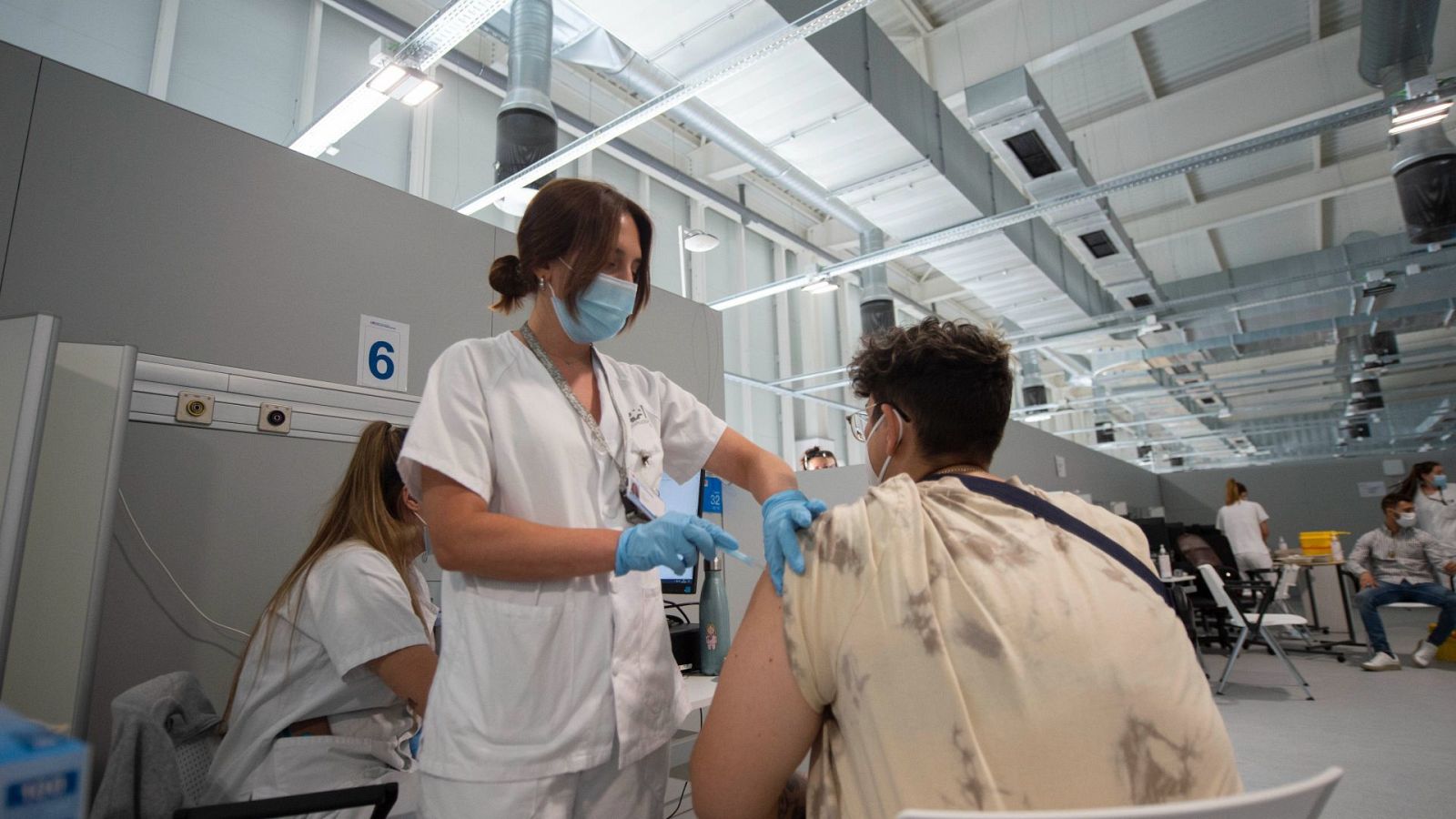 Un joven recibe la primera dosis de la vacuna Pfizer en el Hospital Zendal de Madrid.