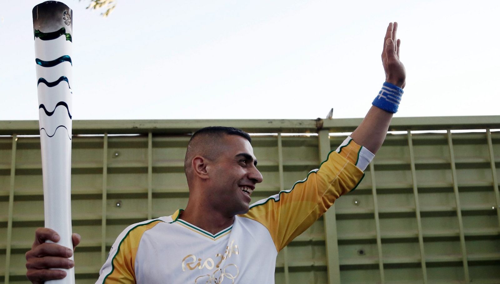 El nadador paralímpico sostiene la antorcha olímpica en el campo de refugiados de Eleonas