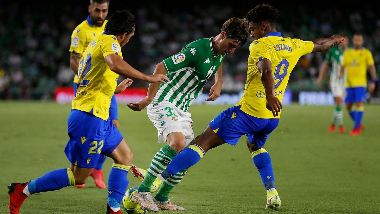 Juan Miranda conduce el balón ante la presión de los jugadores del Cádiz