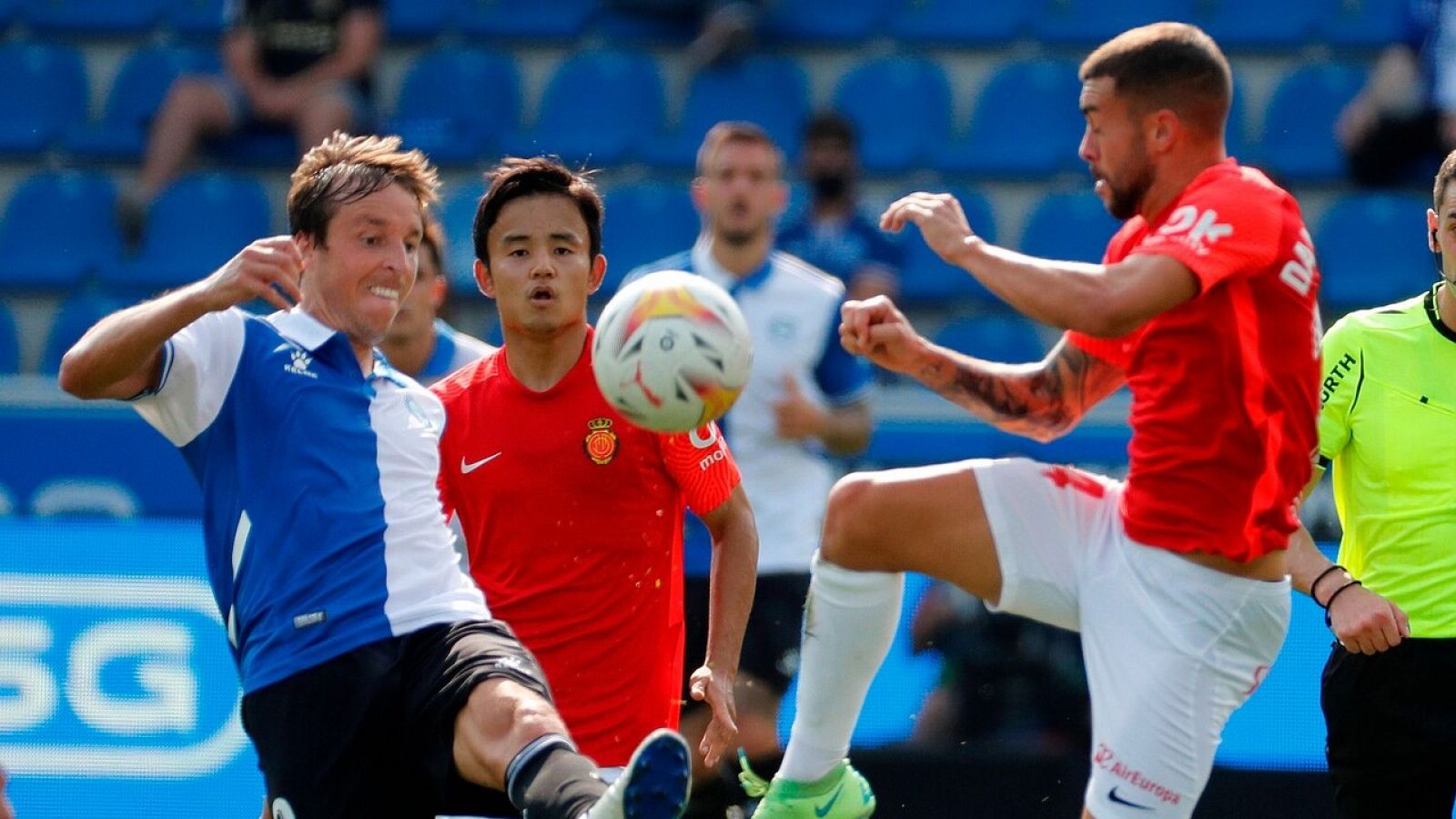 El centrocampista del Alavés Tomás Pina (i) disputa el balón ante los jugadores del Mallorca Dani Rodríguez (d) y Takefusa Kubo (c)