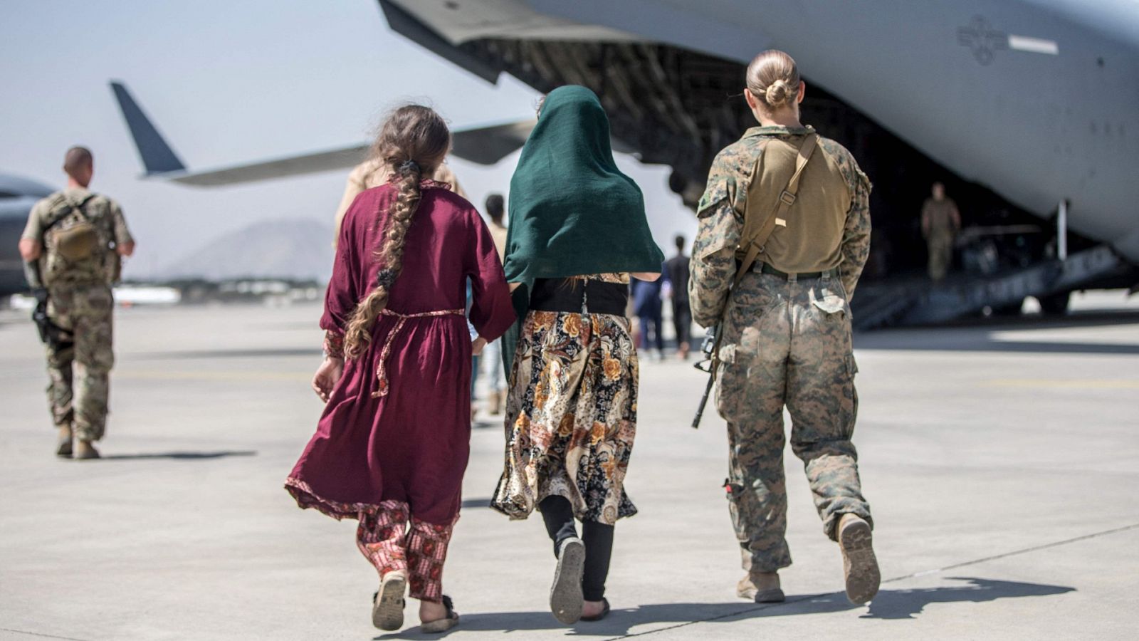 Una militar estadounidense evacuando a dos mujeres afganas en el aeropuerto de Kabul