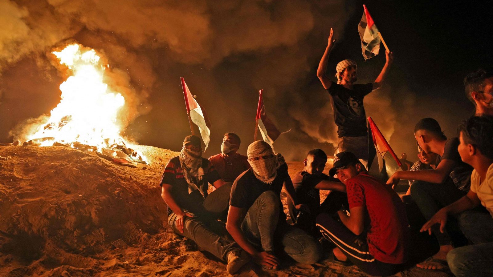 Palestinos durante una protesta nocturna junto a la valla fronteriza con Israel