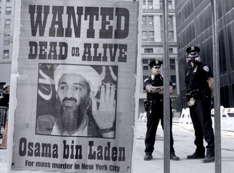 11-S: Dos policías al lado de un cartel repartido por un diario de Nueva York, del 18 de septiembre de 2001, que pide la captura de Osama Bin Laden