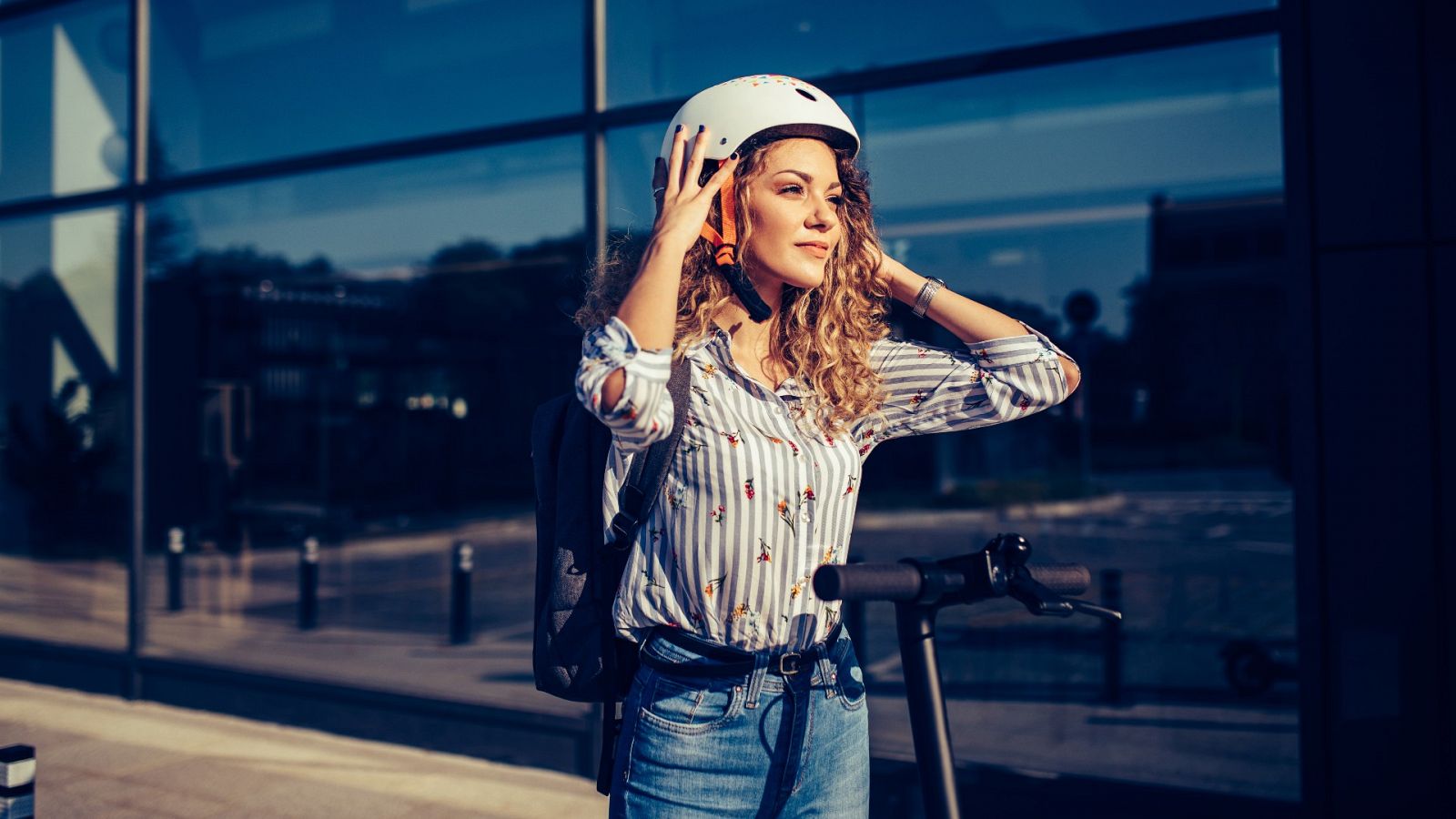 Mujer con casco en un patinete