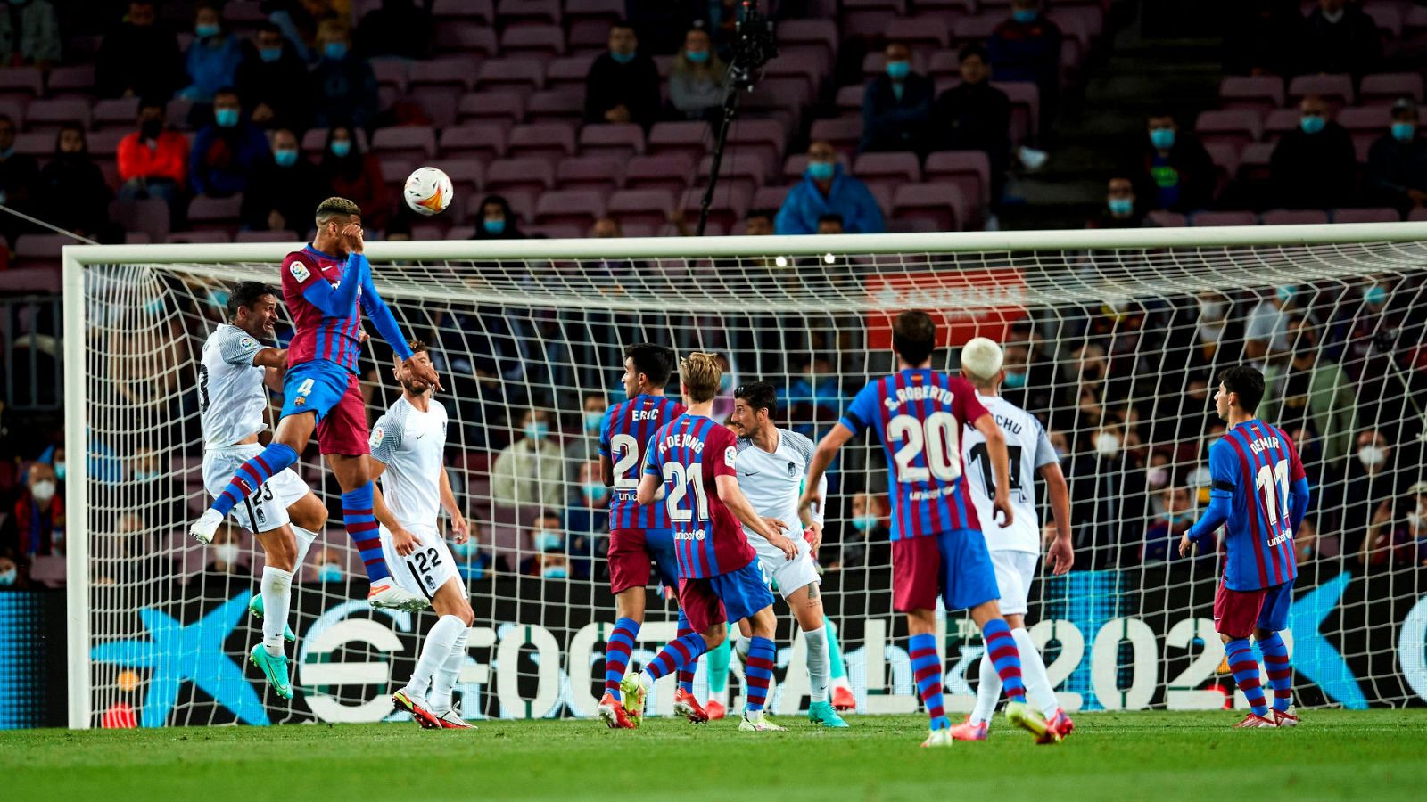 El defensa uruguayo del FC Barcelona Ronald Araújo (elevado sobre el resto, 2º por la izqda) remata de cabeza ante el Granada